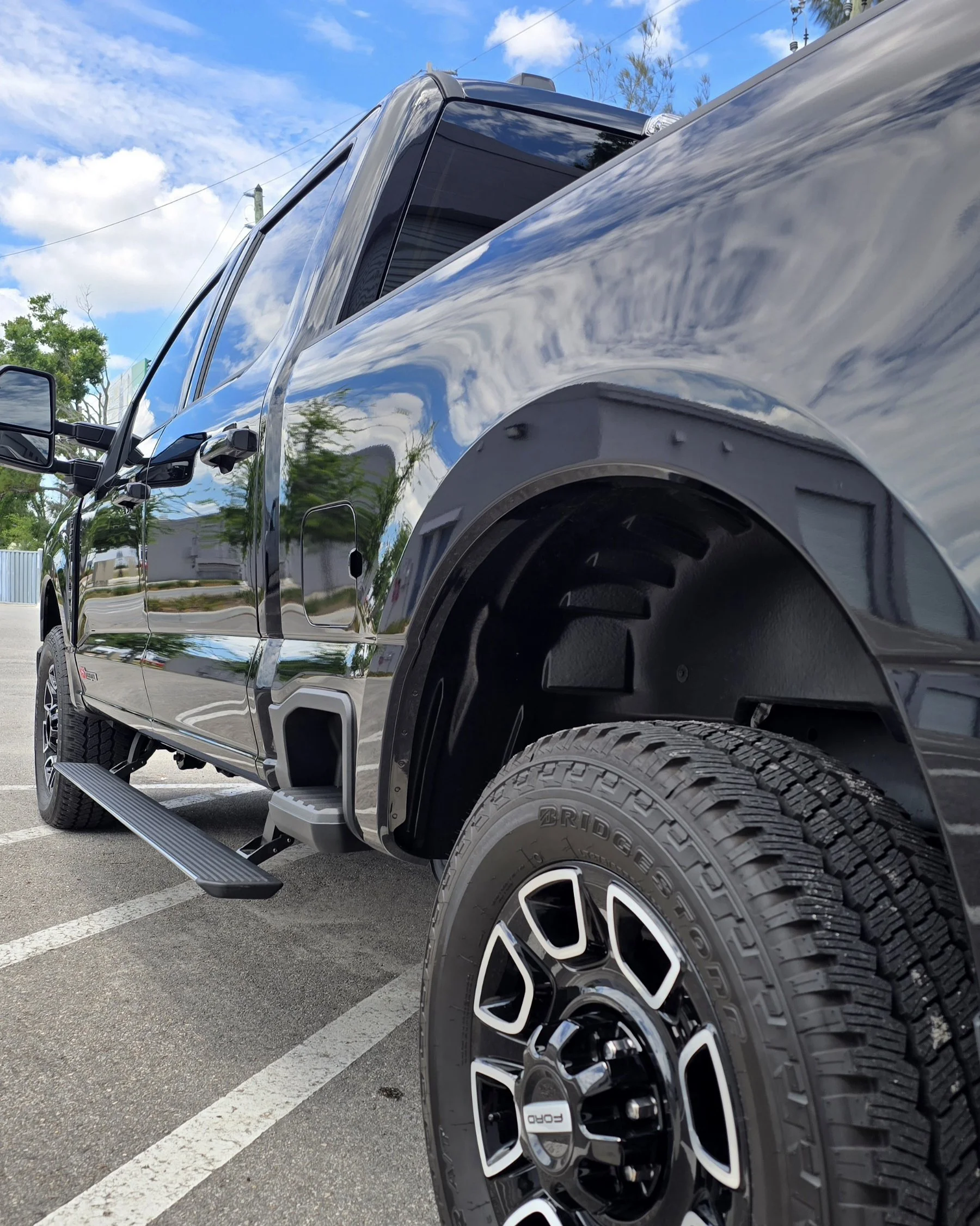 2025 Ford F-250 Super Duty black mirror finish paint with 25-yer self-healing ceramic coating outside Miyagi Motorworks studio