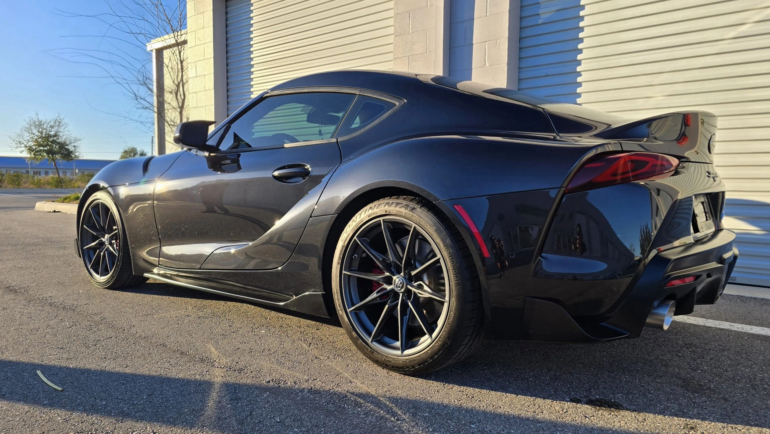 toyota supra with black paint in the sunset after paint correction and ceramic coating