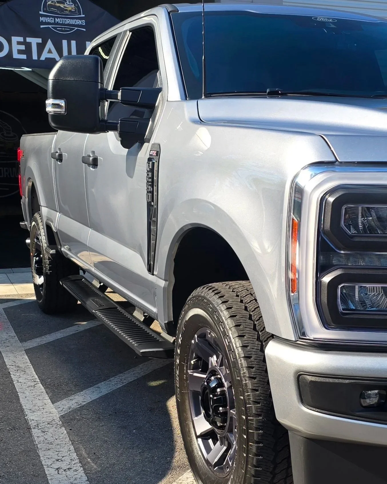 Silver Ford F-250 Super Duty front three-quarter view showcasing a high-gloss finish after a professional paint correction and premium ceramic coating installation.