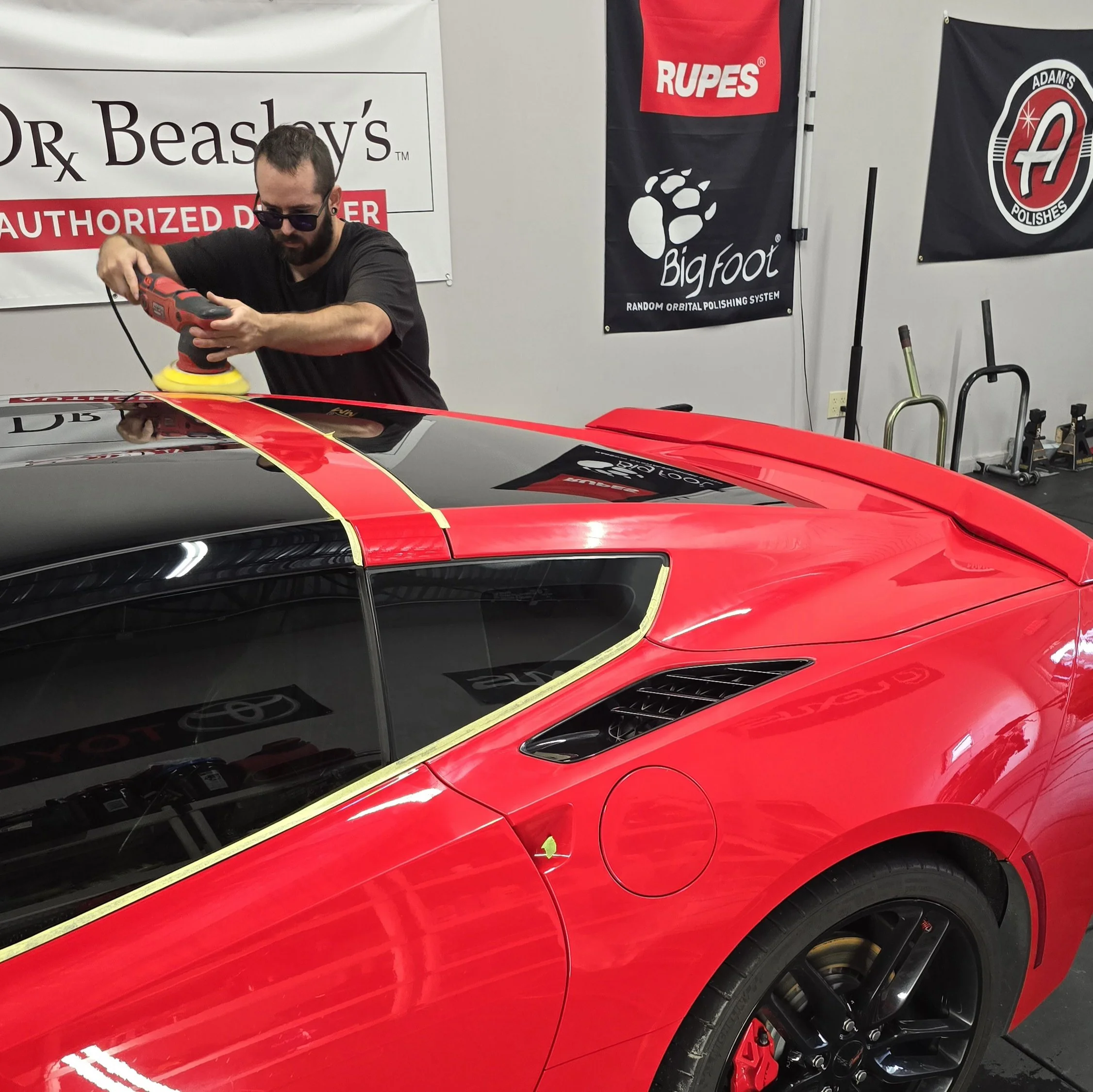 Red corvette getting paint correction inside the studio in Largo, FL