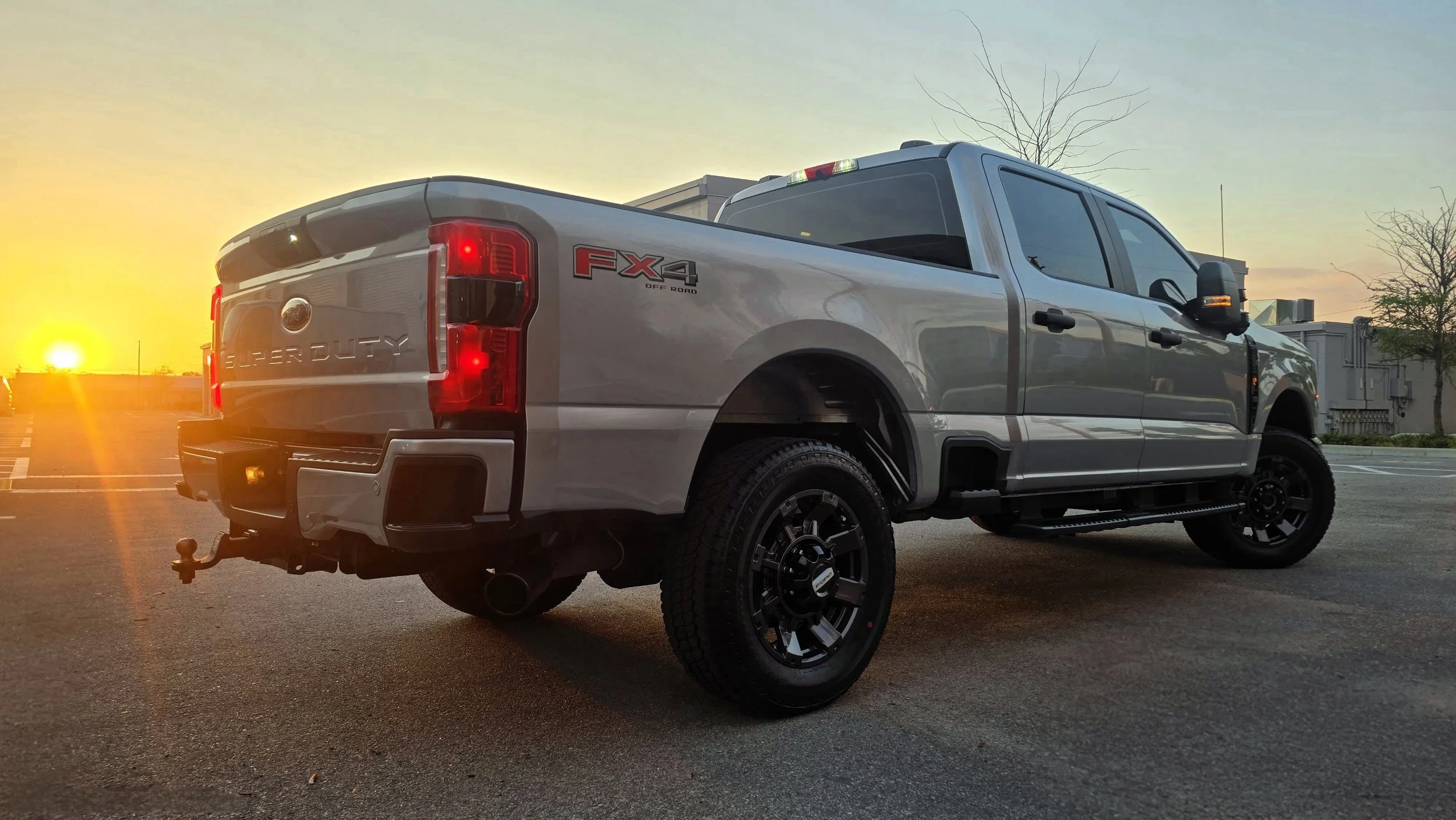 silver ford f250 super duty after paint correction and ceramic coating outside Miyagi Motorworks with sunset in background