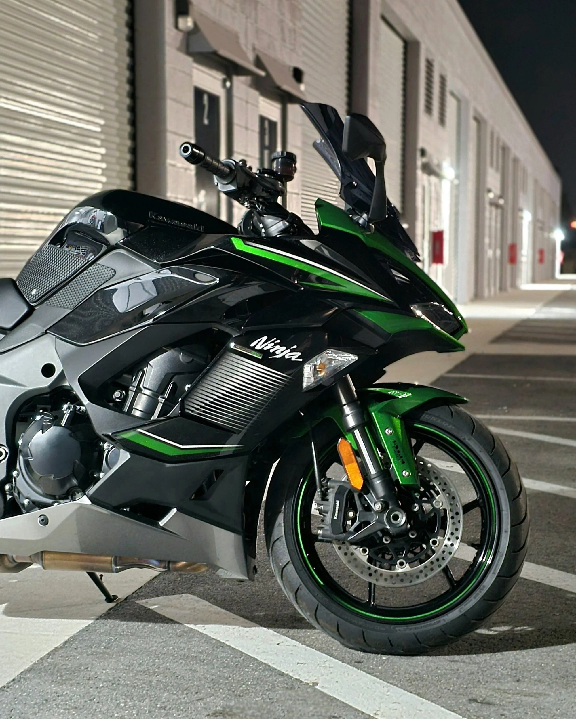 Polished and spotless green and black Kawasaki Ninja 1000sx with ceramic coating at night outside of Miyagi Motorworks