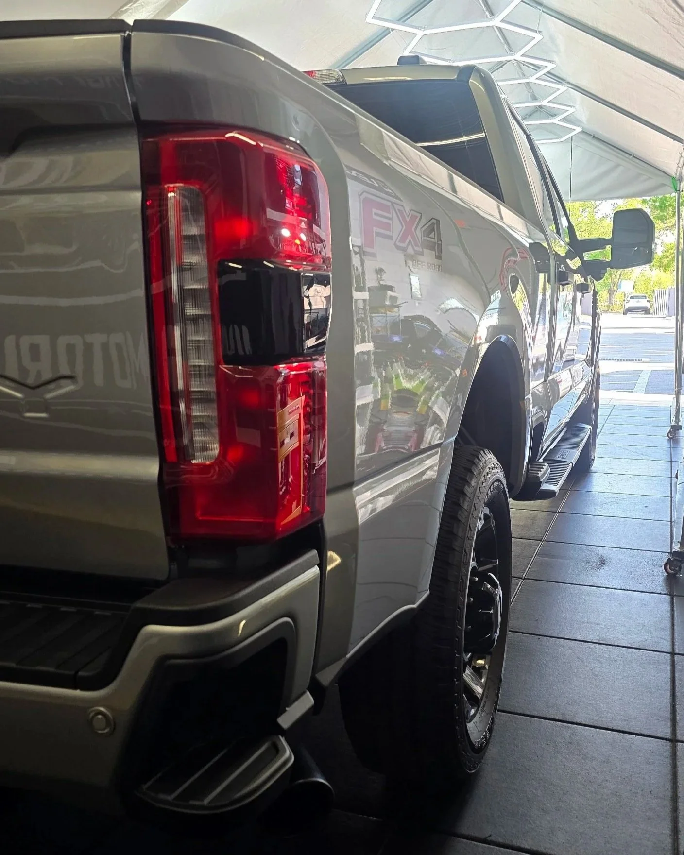 Silver Ford F-250 Super Duty truck rear quarter panel showing high-gloss paint reflection after a premium 7-year ceramic coating application at Miyagi Motorworks in Largo, FL.