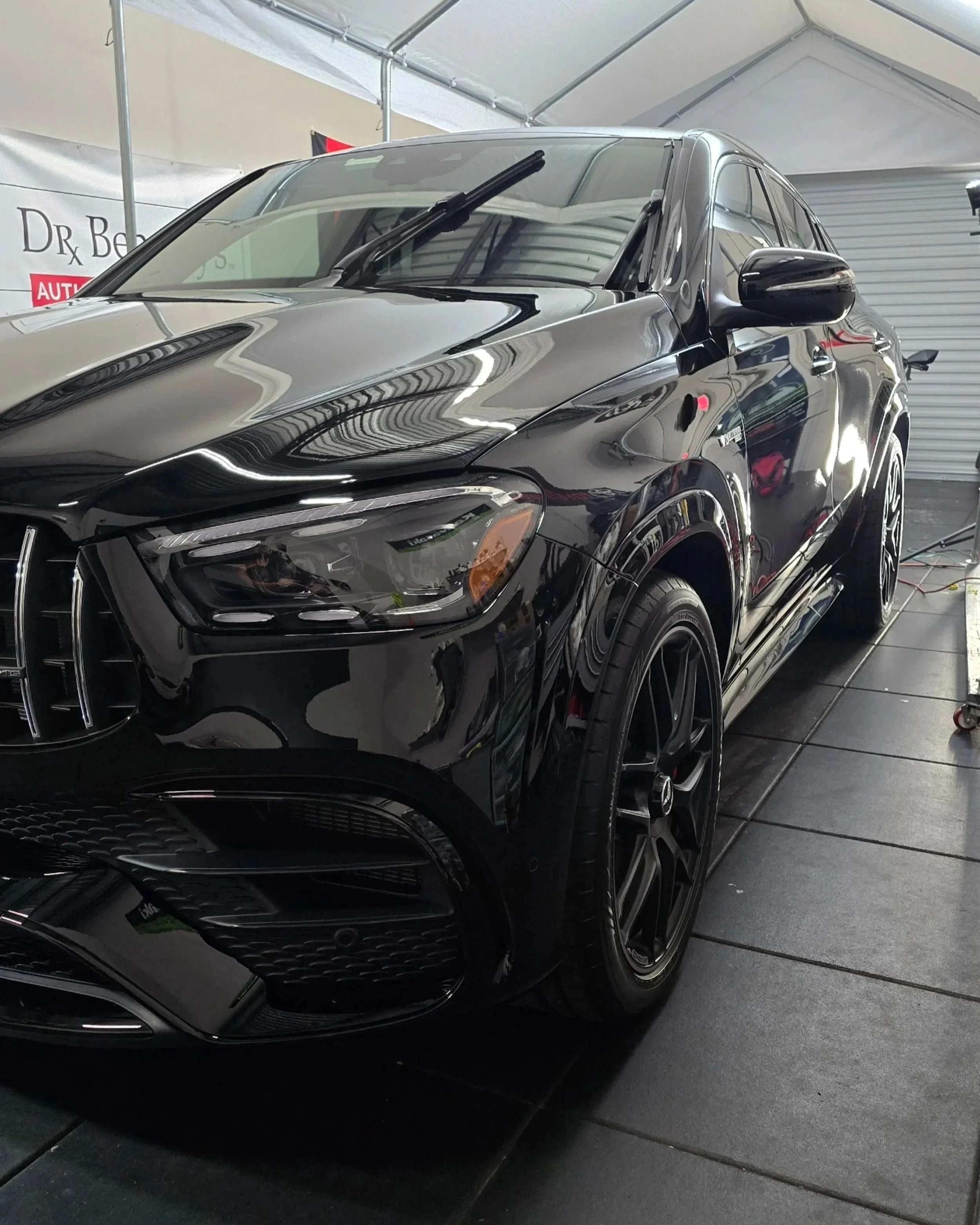 Close-up of a glossy black Mercedes-Benz SUV after a paint correction and ceramic coating service at Miyagi Motorworks in Largo, FL.