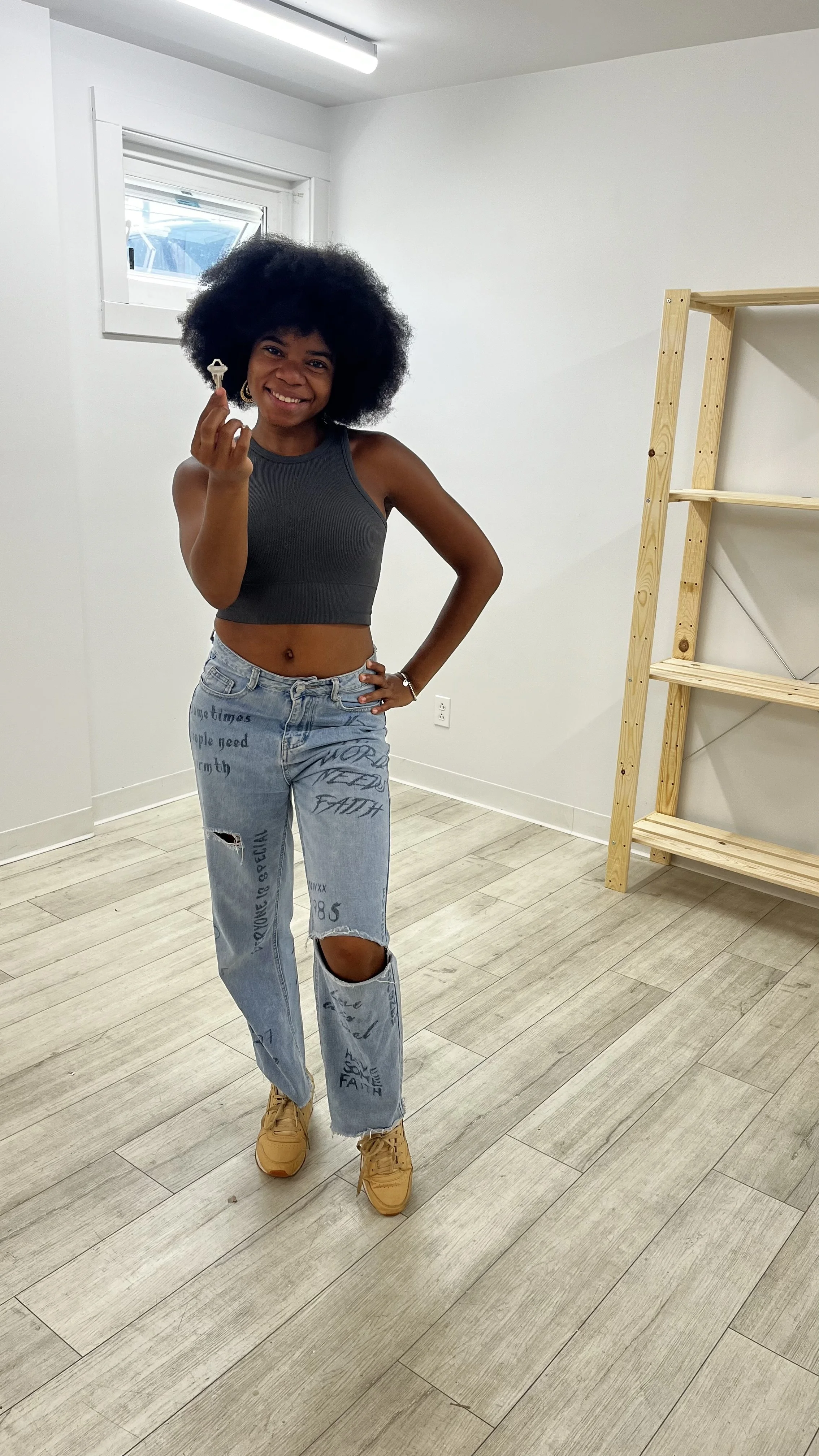 That Creative Space, artists Art studio or workspace with a gallery wall featuring abstract art, photos, and a clock on a beige wall. Various art supplies are on the foreground table.