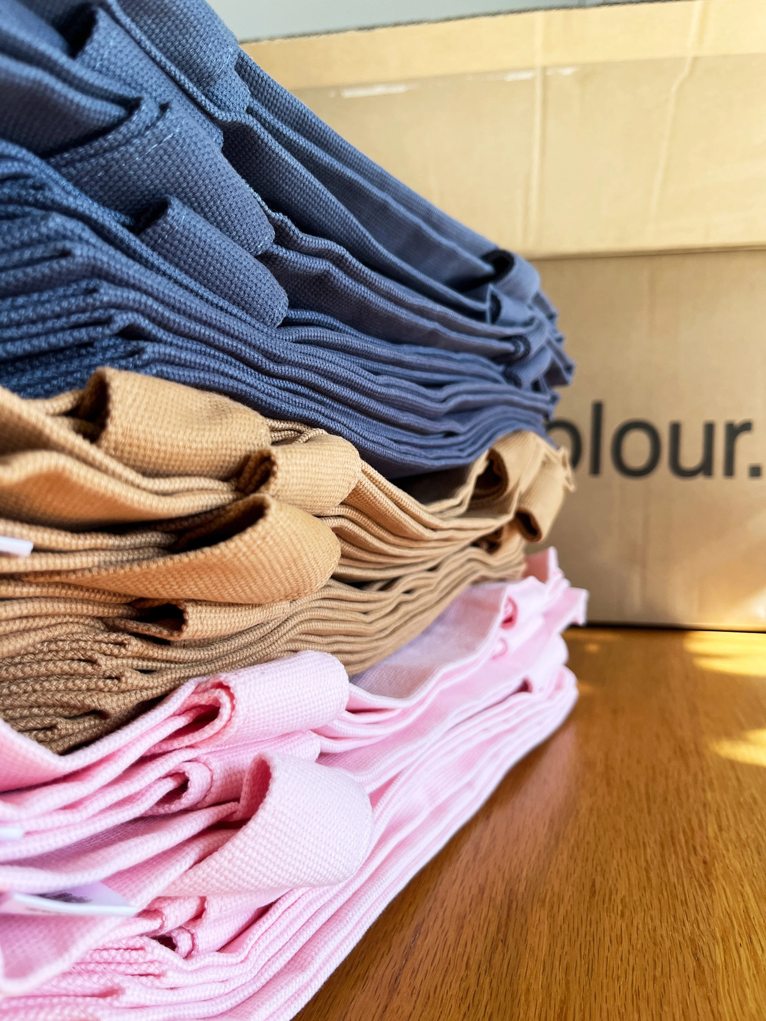 Stack of AS Colour tote bags
