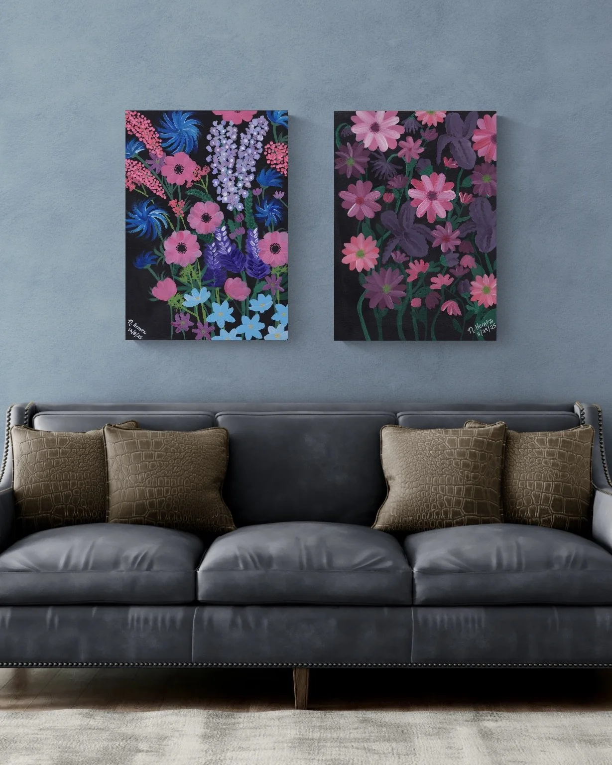 Grey leather sofa against a gray wall.  On the wall are two floral paintings on black backgrounds.  The florals are colored in shades of pink, purple lavender and blue.