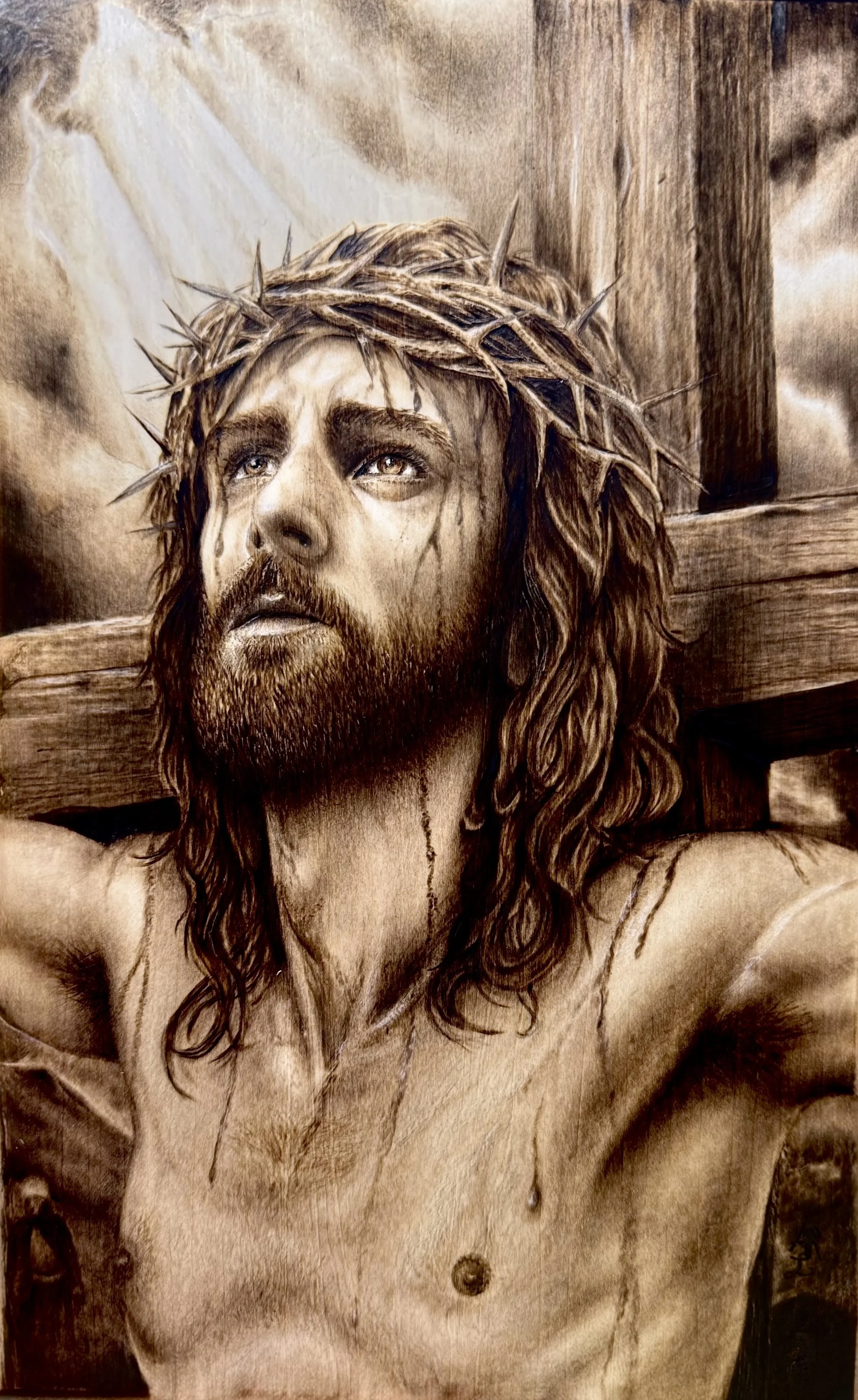 IT IS FINISHED
This pyrography artwork captures Christ on the cross with powerful emotion and detail. His upward gaze and the light behind Him convey both suffering and unwavering faith. Rich wood-burned tones and intricate textures bring depth and r