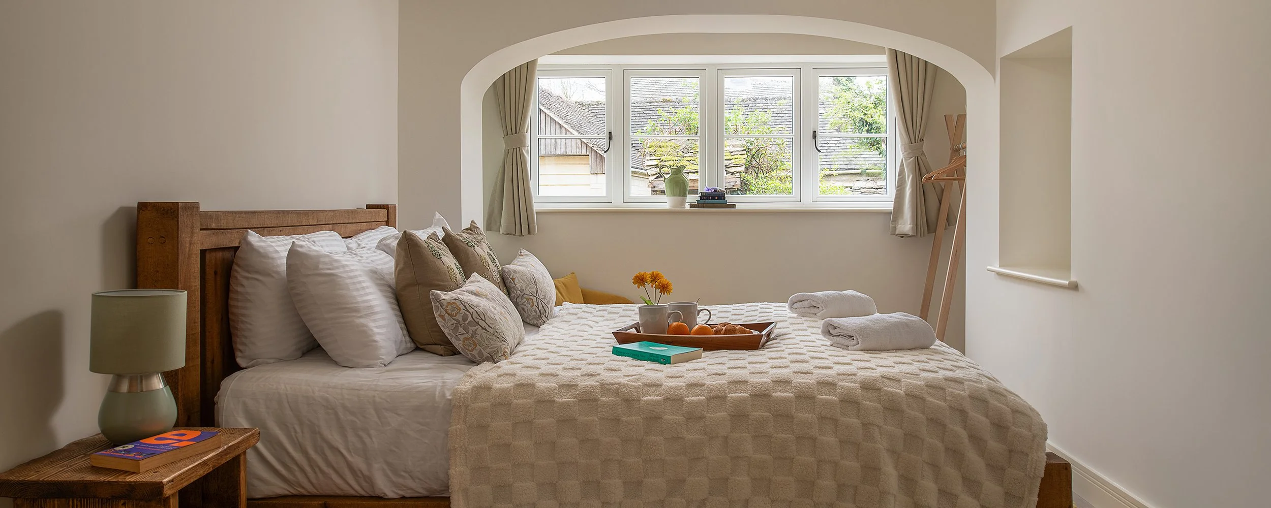 Cosy bedroom at Well Cottage in the Cotswolds near Cirencester, with breakfast tray on the bed.