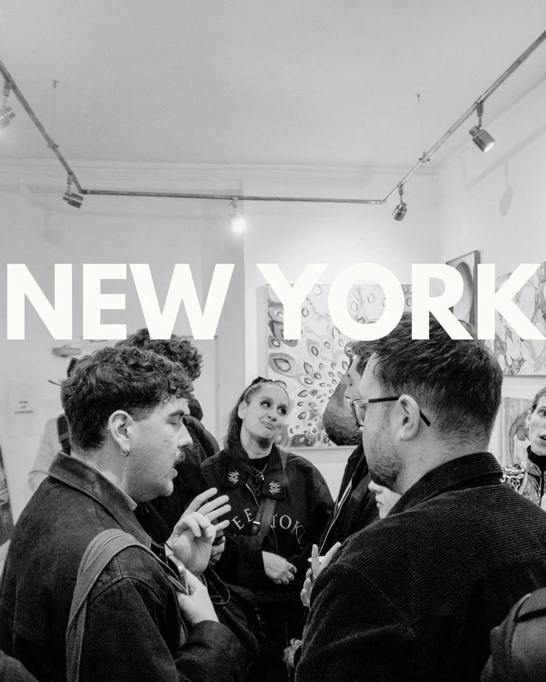 People speaking and listening in an art gallery with paintings on the wall, with overlaid text that says 'New York'.