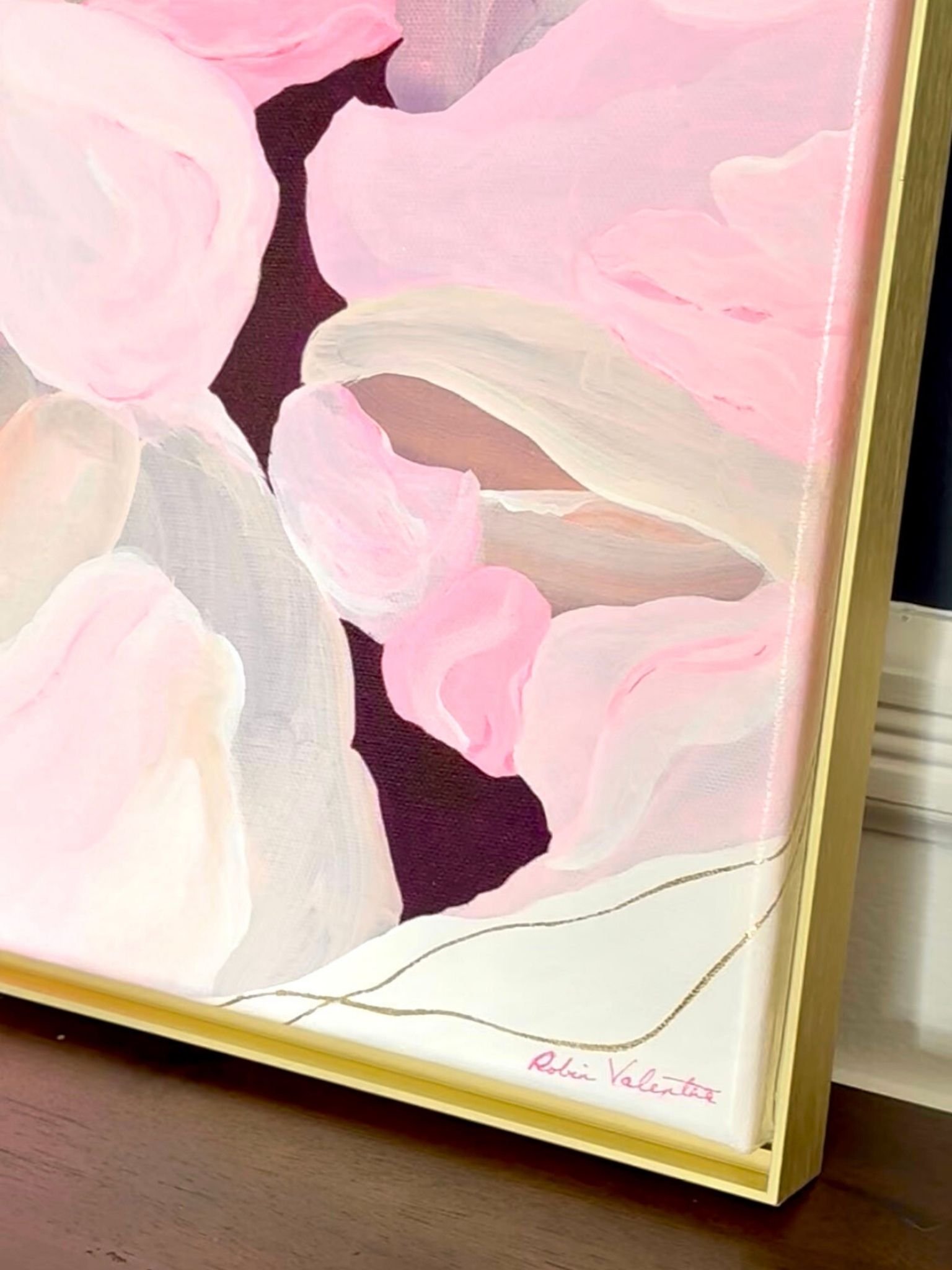 A corner view of Where the Petals Land resting on a credenza—gold leaf and soft florals meeting at the frame’s edge.