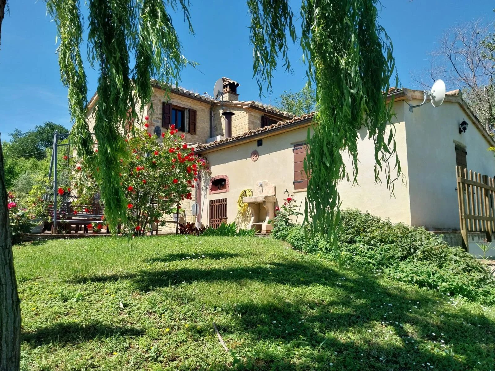 Back garden of a traditional stone house for sale in Le Marche, Italy.
