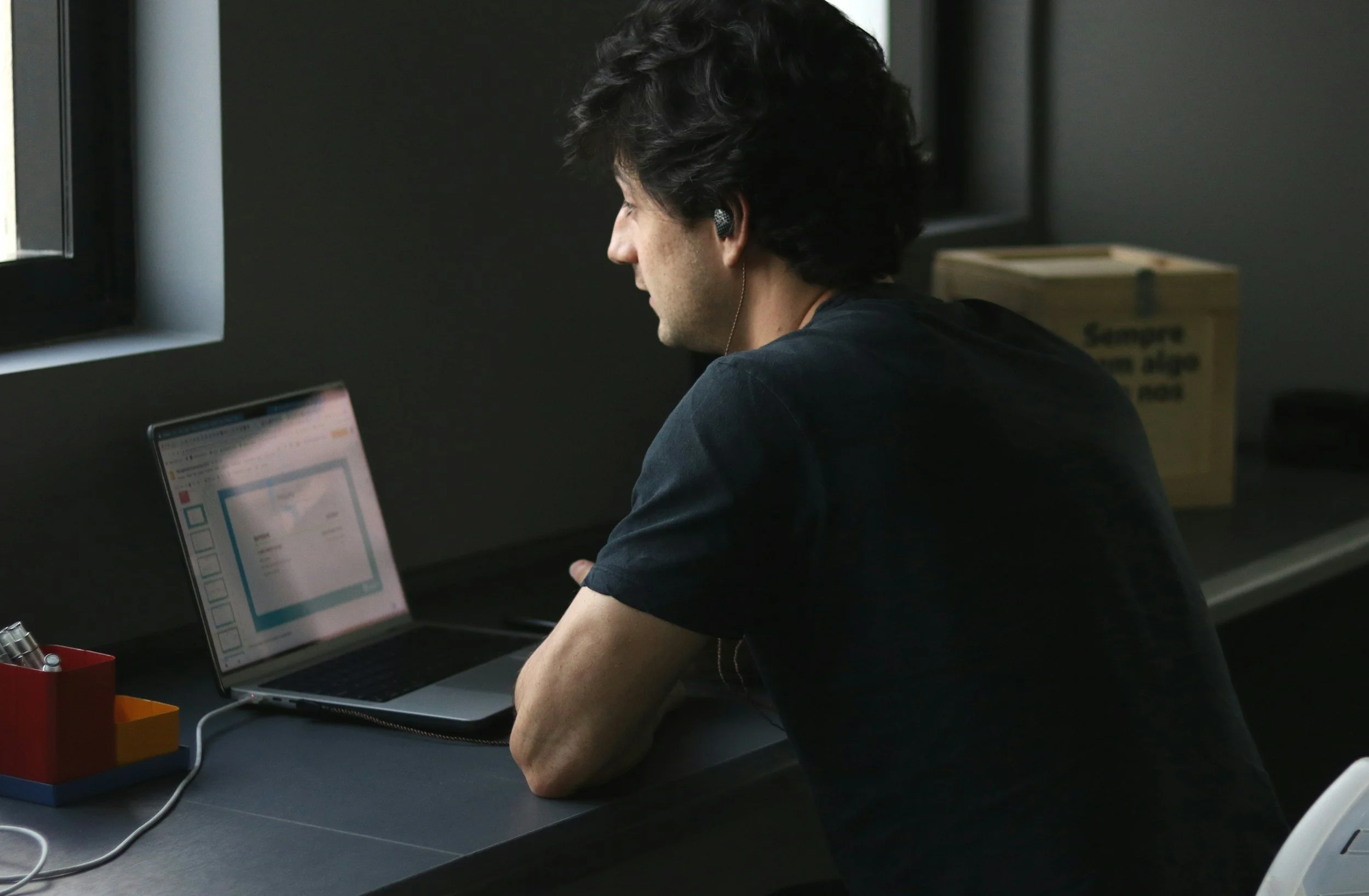 A student focused on an online course or project at their desk, wearing headphones, representing eLearning and remote education.