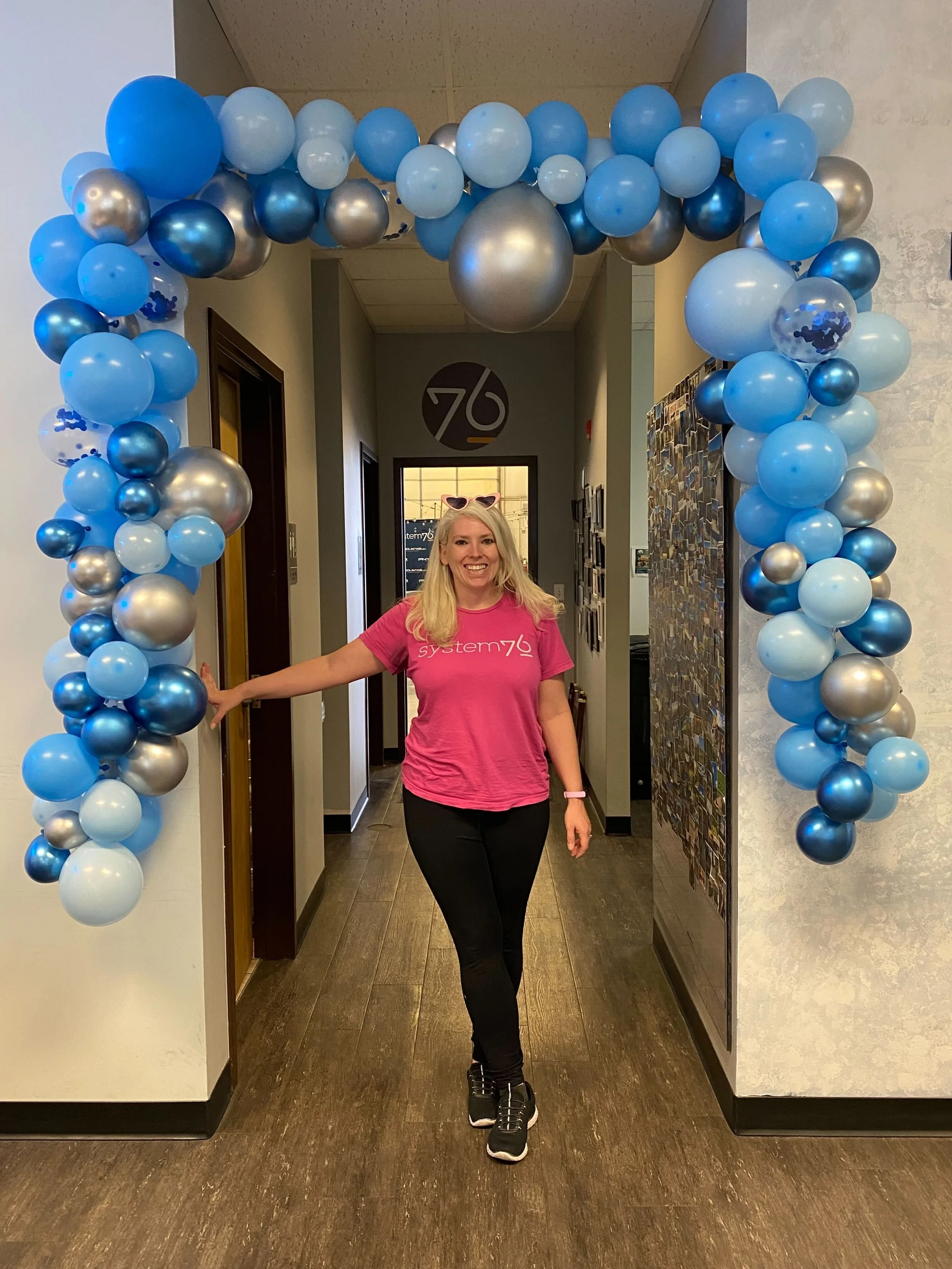 blue and silver balloon garland with Emma underneath