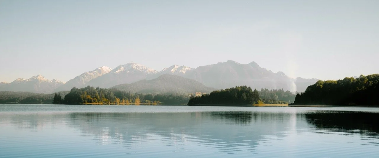 Paisaje natural con laguna, montañas nevadas y bosques