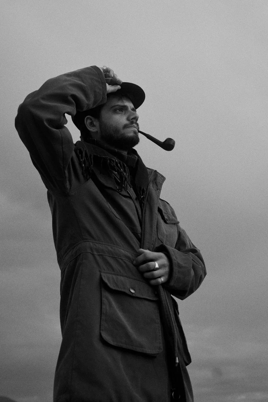 Hombre con barba y sombrero mirando al horizonte, con pipa en la boca, en una foto en blanco y negro.