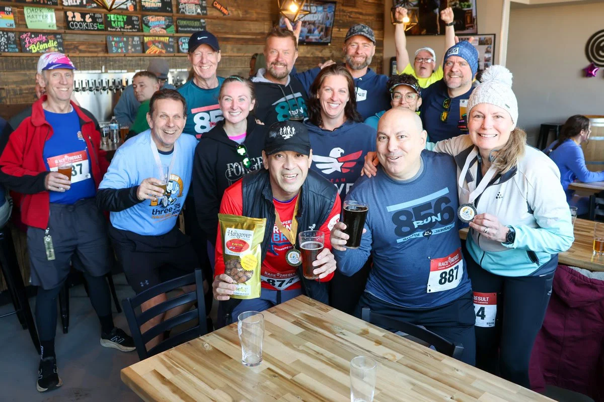 A group of runners celebrating after the Three 3's Race Day race.