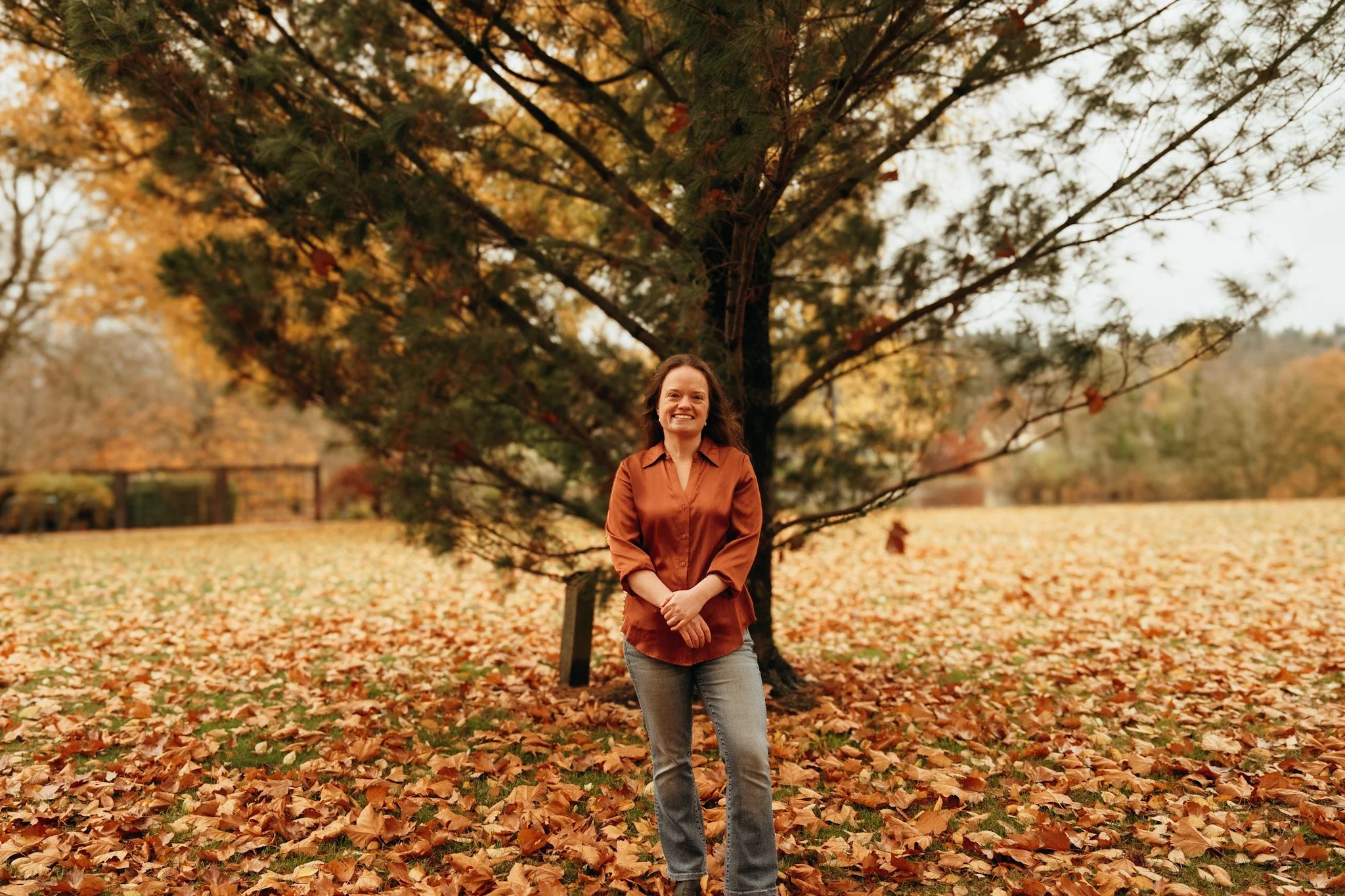 An outdoor portrait of Laurel LeMohn. The image reflects a calm, grounded presence and aligns with themes of trauma-informed care, somatic awareness, nervous system regulation, and nature-based healing.