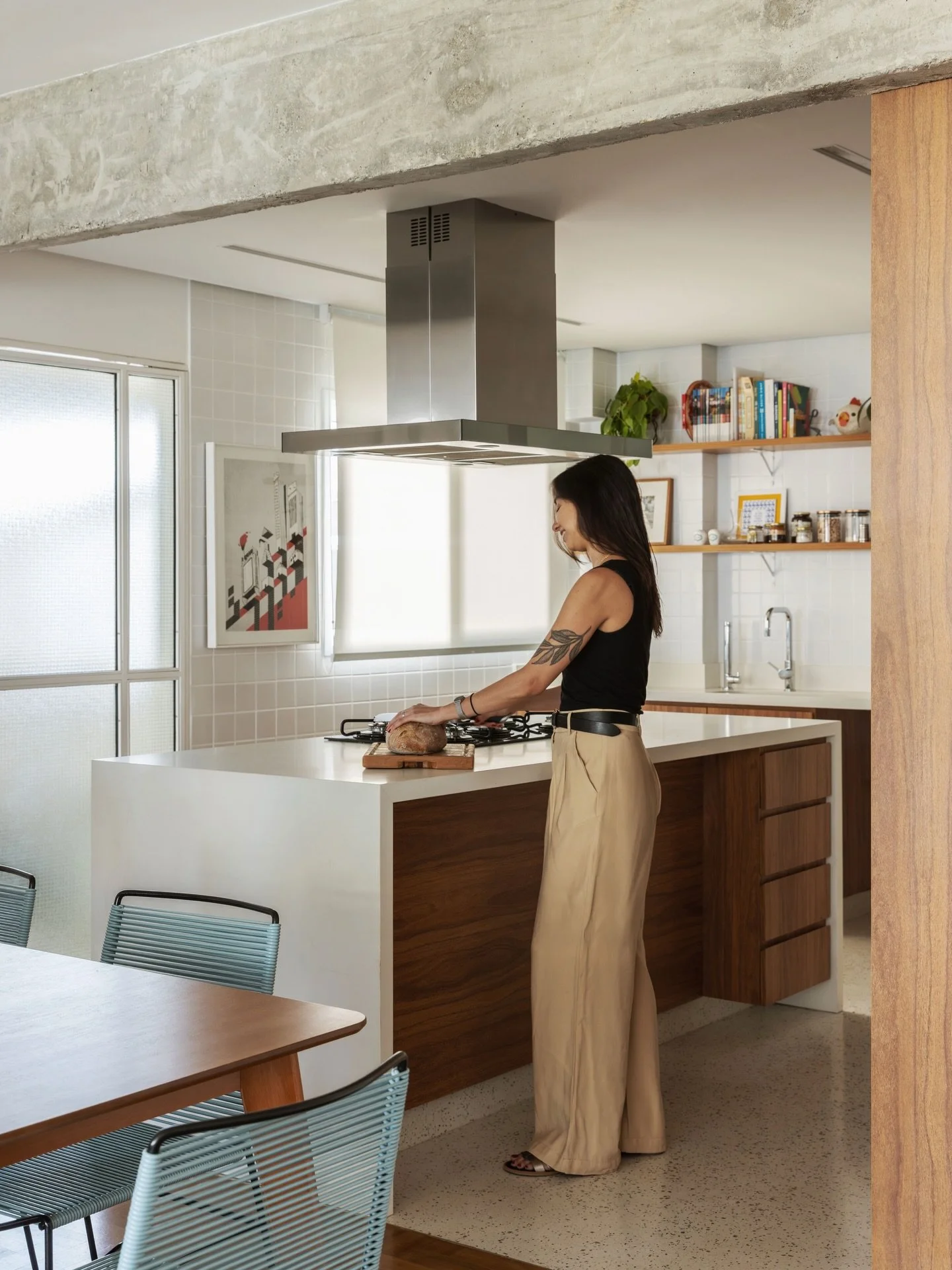 No centro da cozinha, a ilha organiza o espa&ccedil;o e convida ao encontro.

A marcenaria em madeira aquece a composi&ccedil;&atilde;o, enquanto a bancada clara e os azulejos refletem a luz natural, criando um ambiente leve e funcional. Acima, a est