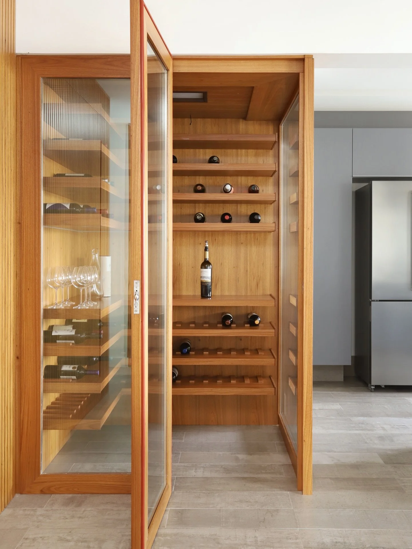 Integrada &agrave; &aacute;rea social, esta adega foi desenhada para unir armazenamento e presen&ccedil;a arquitet&ocirc;nica.

A marcenaria em madeira organiza as garrafas e cria um volume acolhedor no ambiente, enquanto as prateleiras e nichos acom