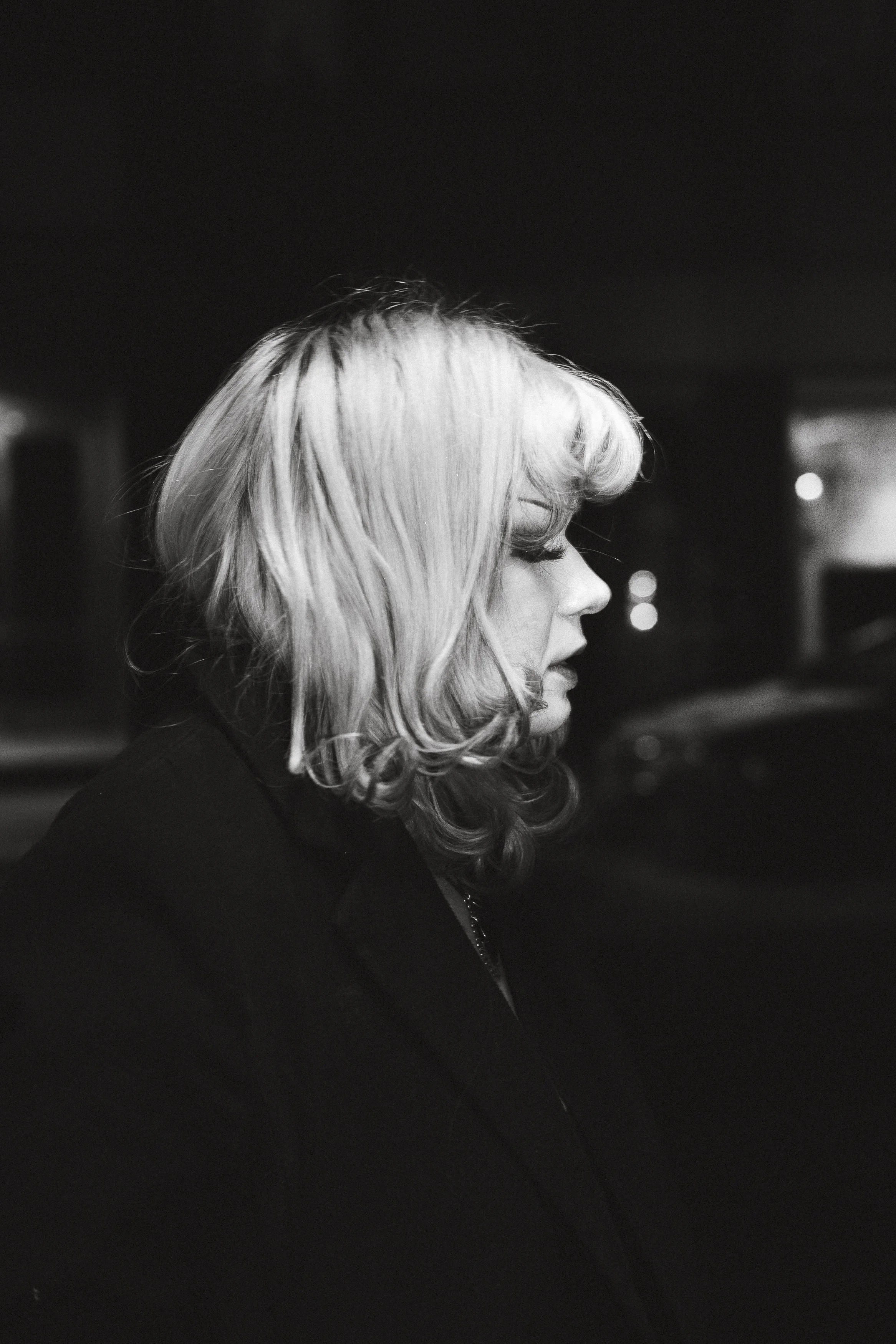 En svartvitbild av en kvinna i profil med ljusa, vågiga hår.