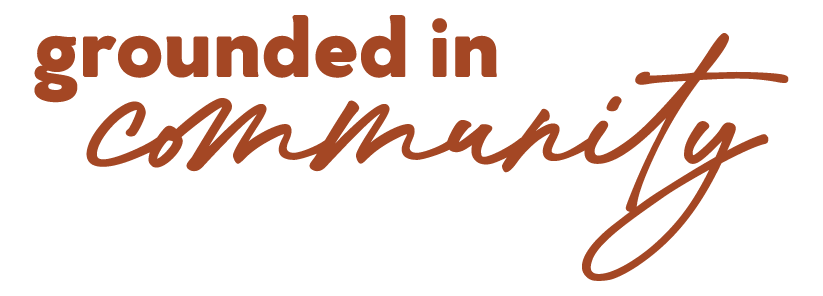 Text graphic with the phrase "grounded in community" in brown lettering, with "grounded in" in bold, uppercase font and "community" in a flowing, cursive style.