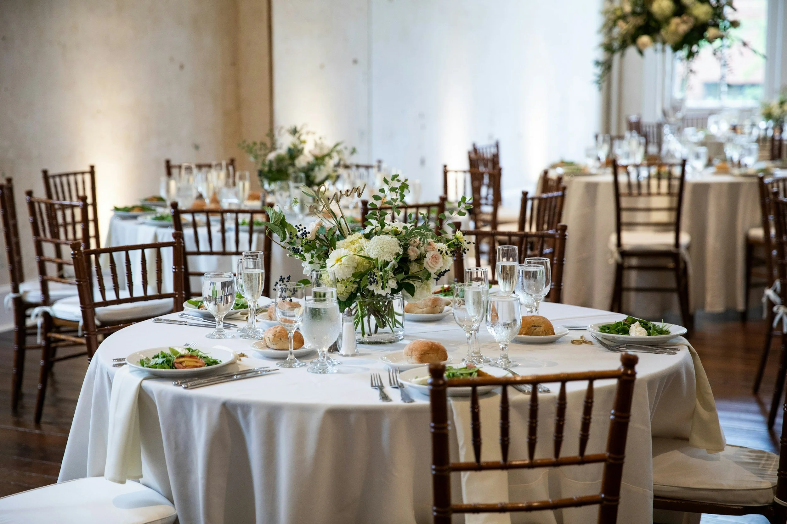 Elegant wedding reception with round tables, white linens, floral centerpieces, and Chiavari chairs at a Central Florida wedding venue, professionally planned by Something Blue Events.