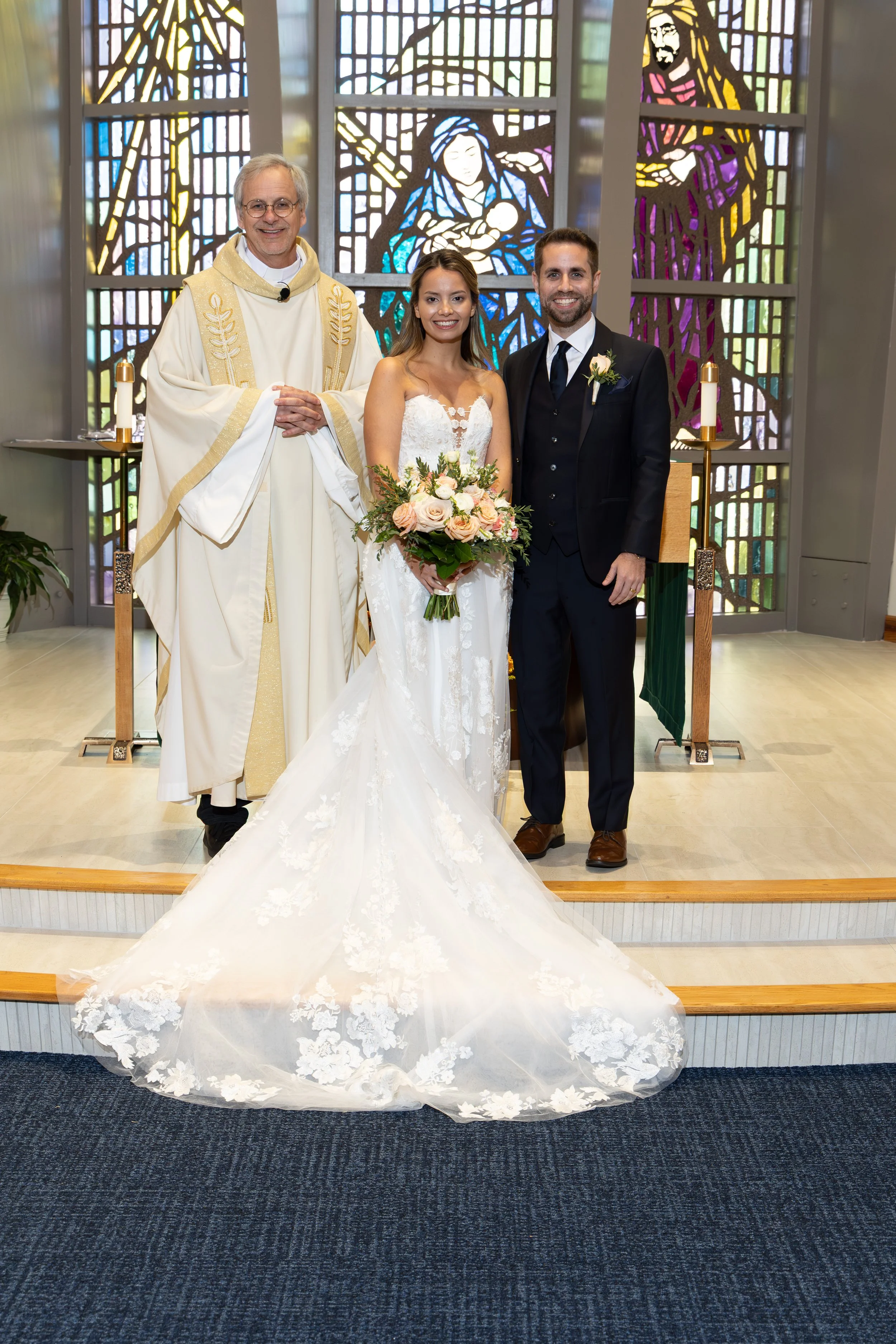 Bride and groom Kimberly and John kneeling before the altar during their Catholic wedding Mass at Nativity Catholic Church in Longwood, Florida.