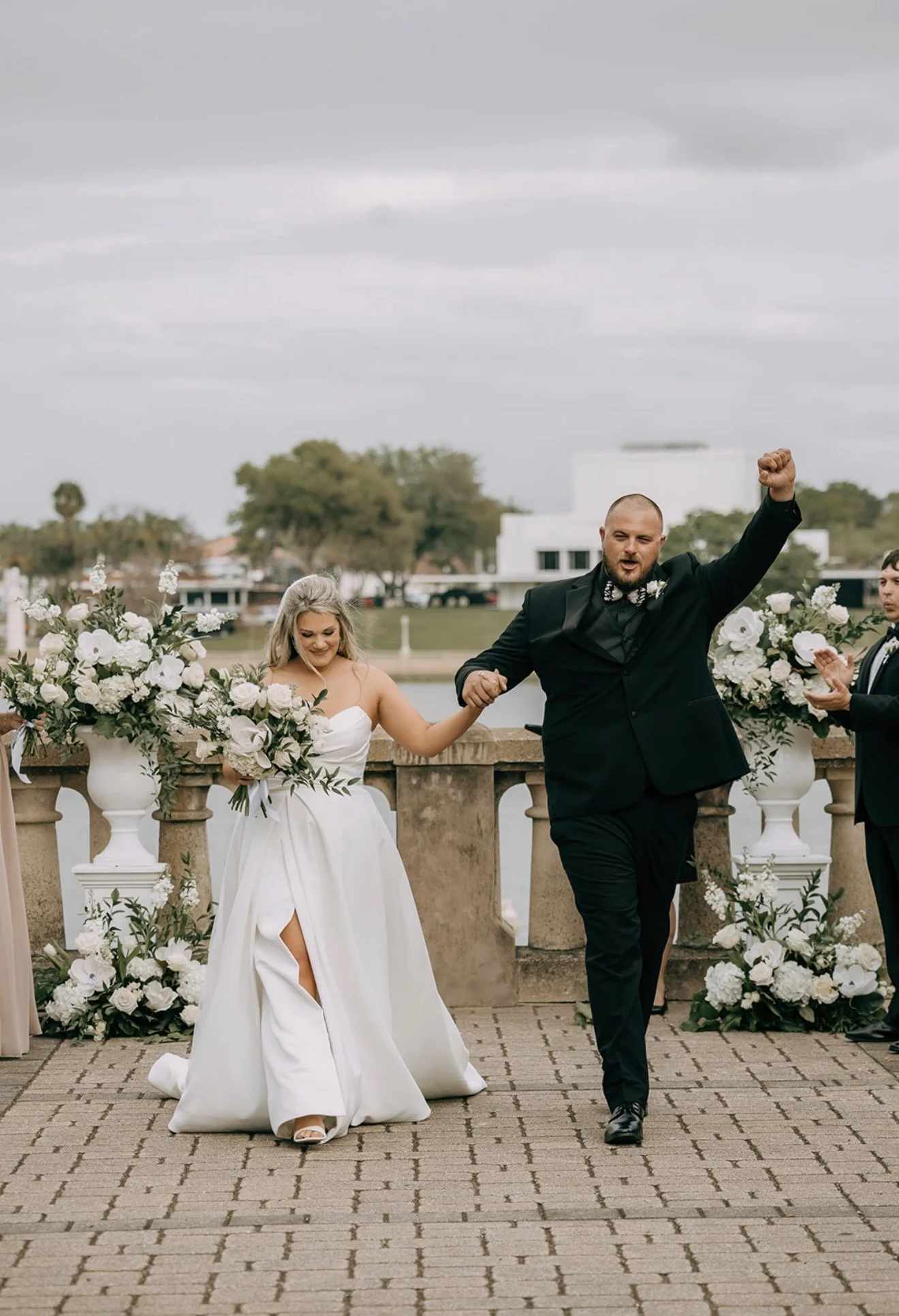 Newly married couple celebrating their wedding recessional during an outdoor ceremony at the Terrace Hotel in Lakeland, Florida, coordinated by Something Blue Events.