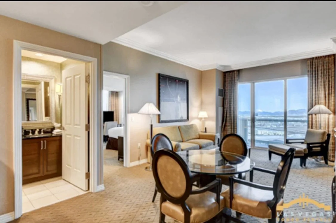 Interior of Penthouse suite with the living area and balcony view of the city and mountains.
