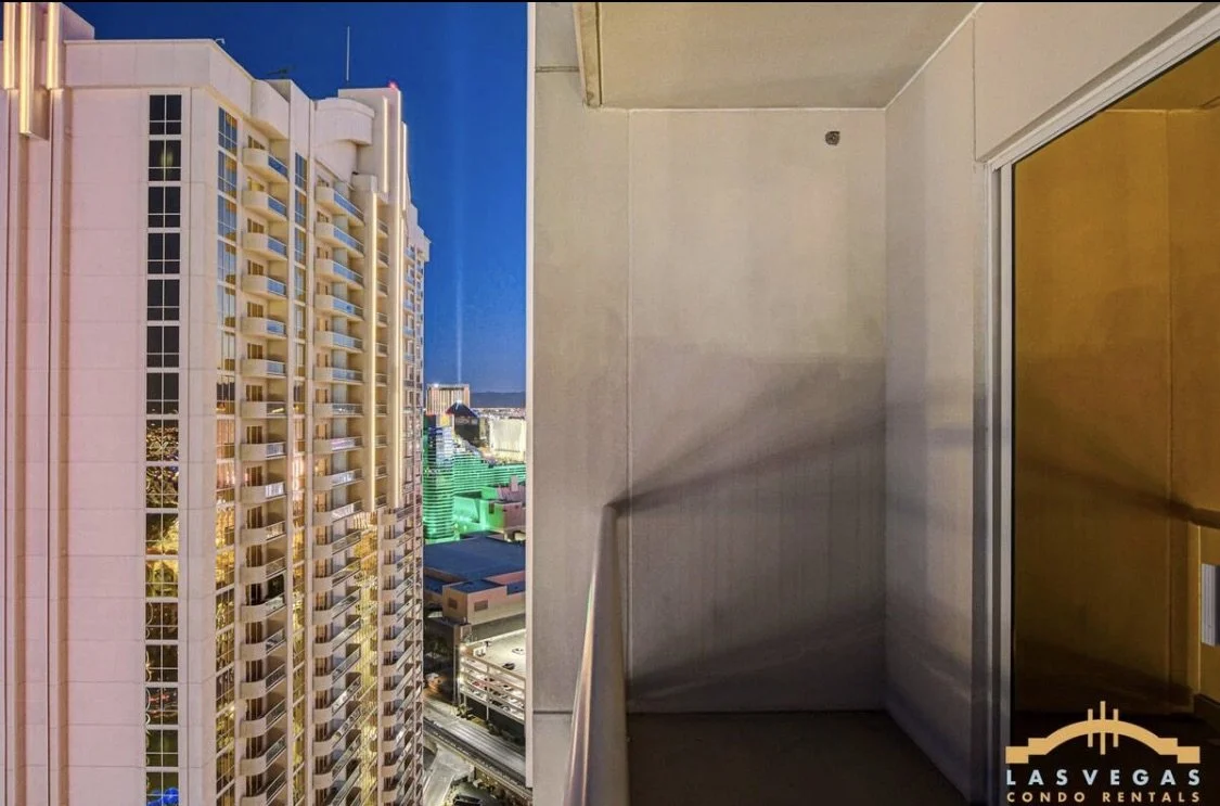 View from the balcony showing the Luxor Pyramid and Las Vegas strip at night.