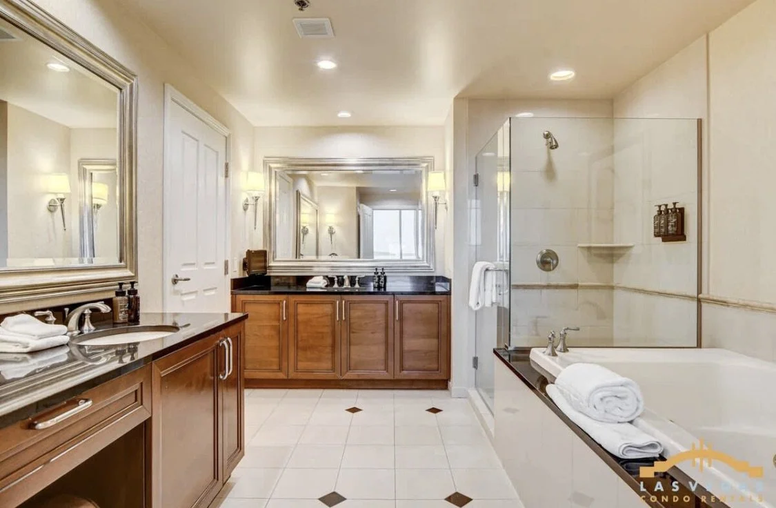 The spacious master bathroom with double vanity sinks, large mirrors, a walk-in shower with glass doors, large jetted bathtub and enclosed toilet room.