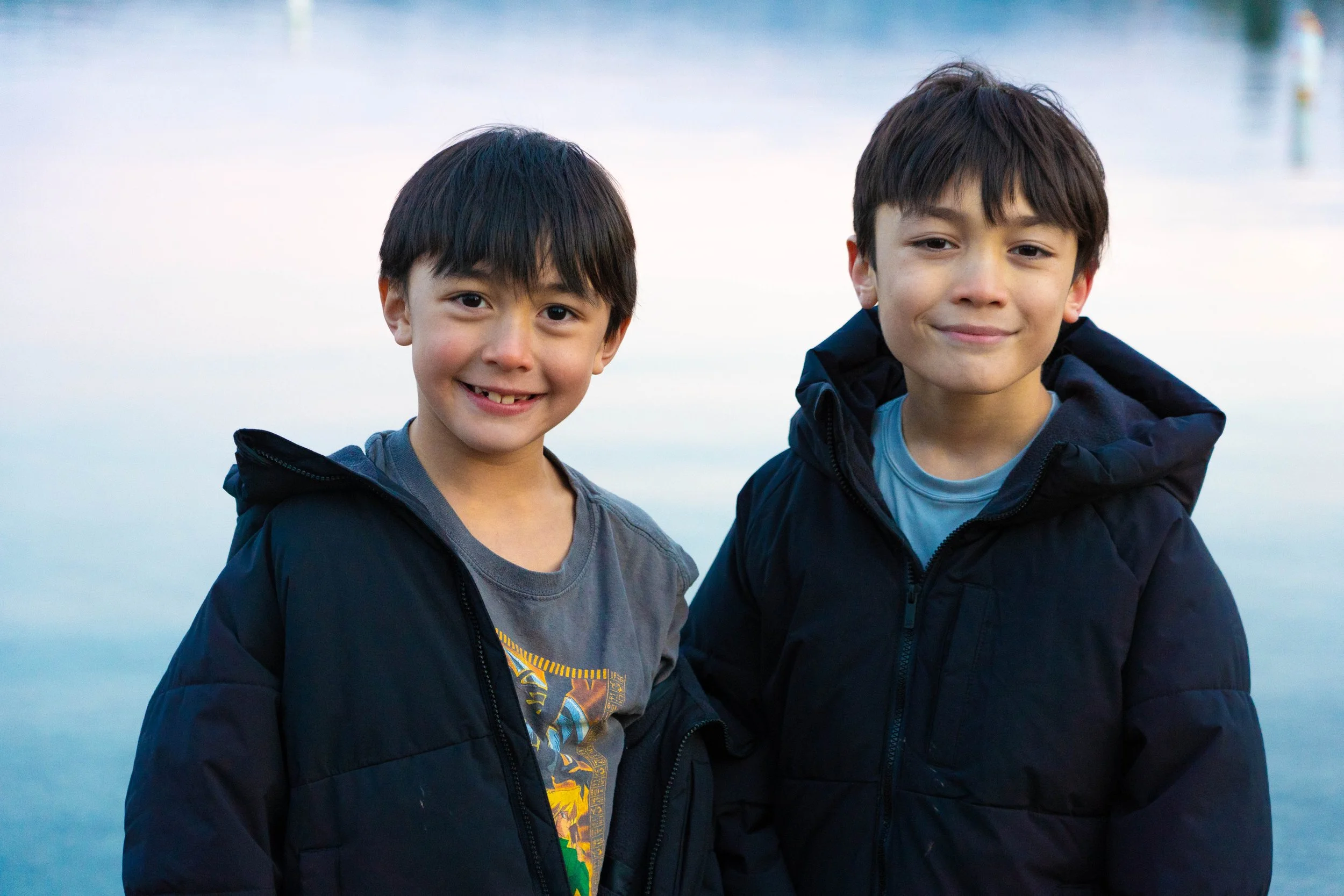 siblings-in-winter-coats-by-lake.jpg