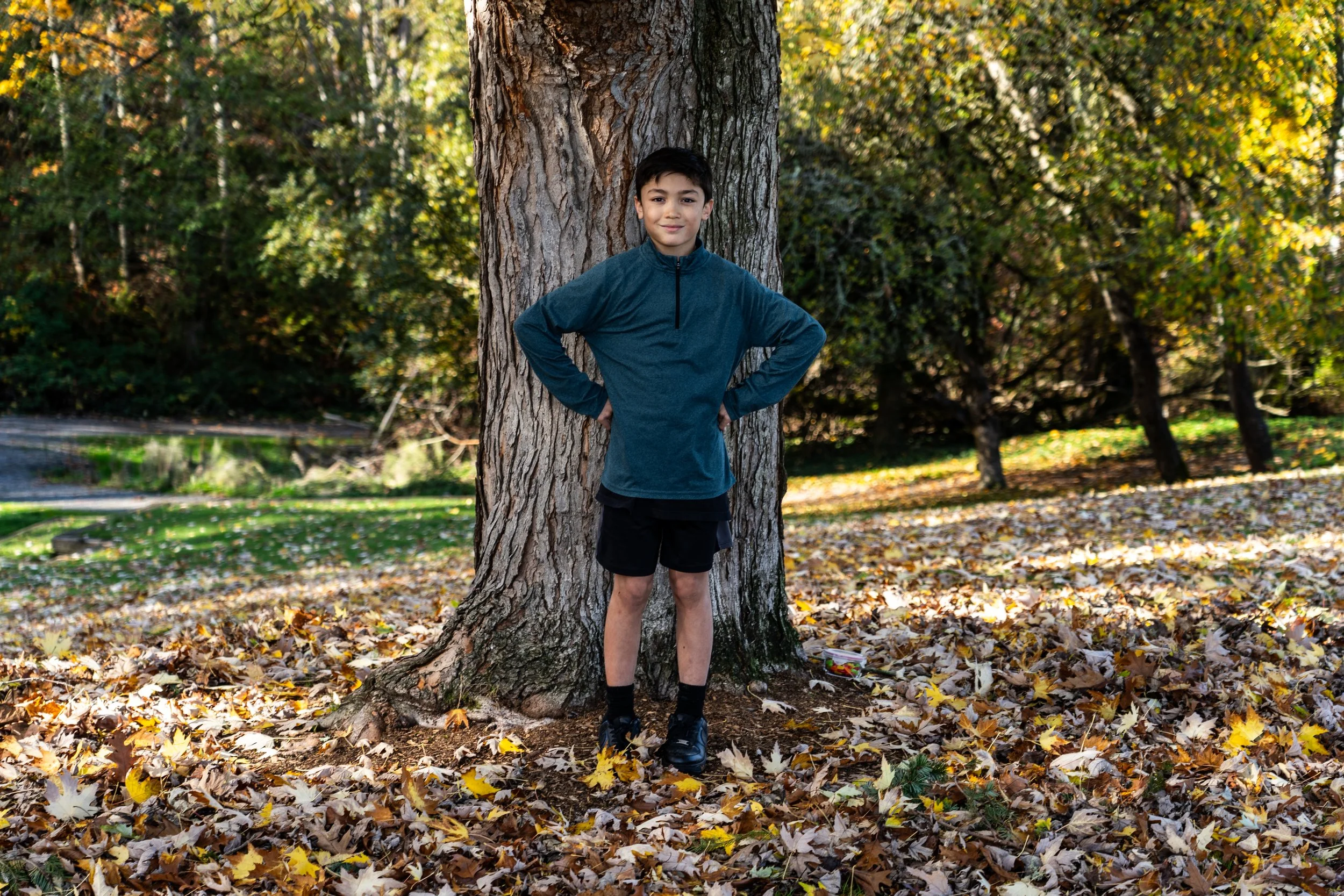 A playful child portrait surrounded by colorful autumn leaves, capturing the wonder and energy of childhood.