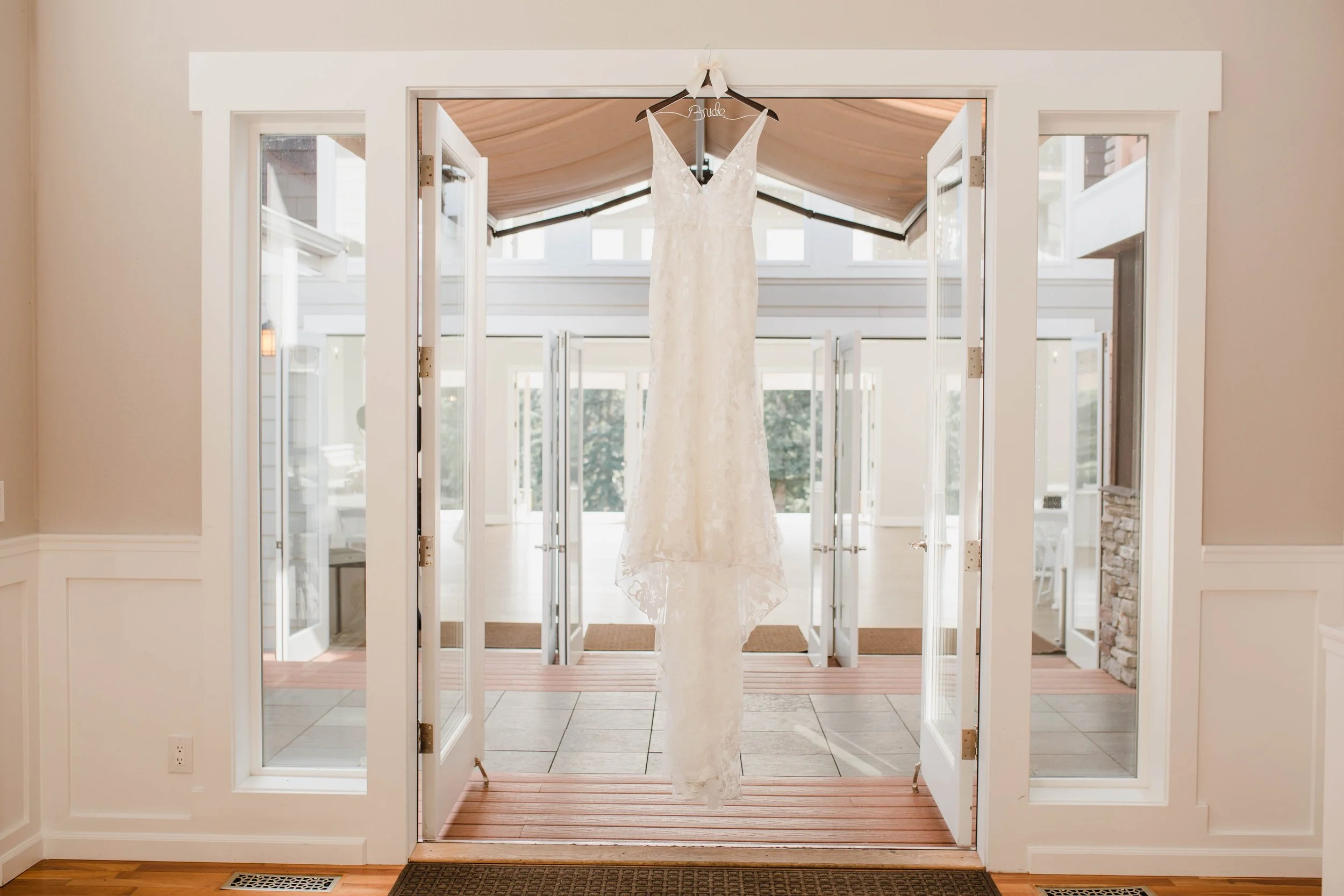 Wedding dress hanging in doorway of a bright, modern room