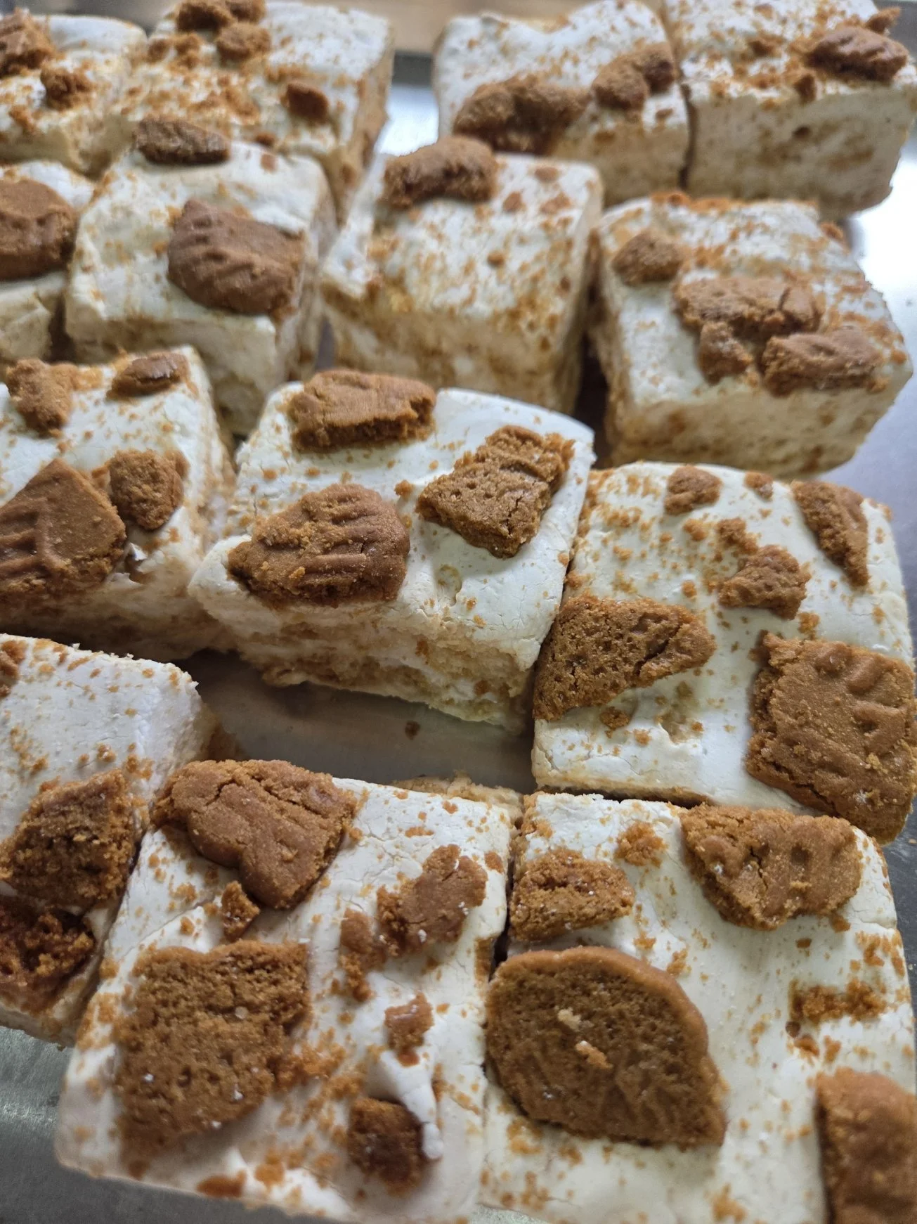 Close-up of marshmallow squares topped with Biscoff cookie pieces.