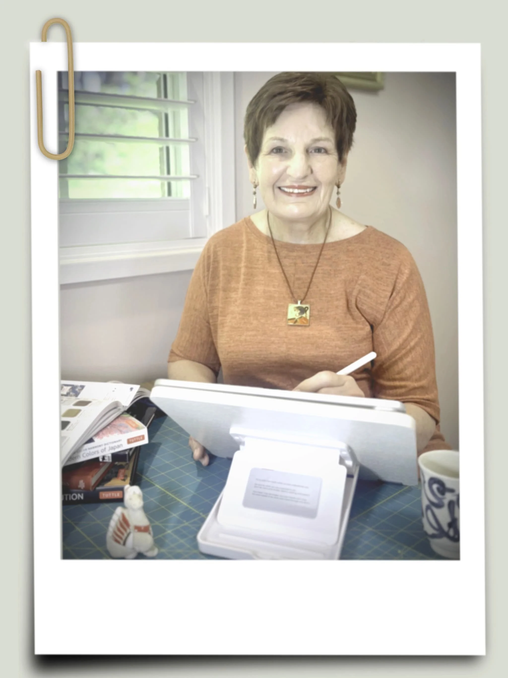 Digital artist Judith Chestnut in her studio, surrounded by Japanese art references and her drawing tablet, demonstrating the intersection of traditional aesthetic and modern technology.