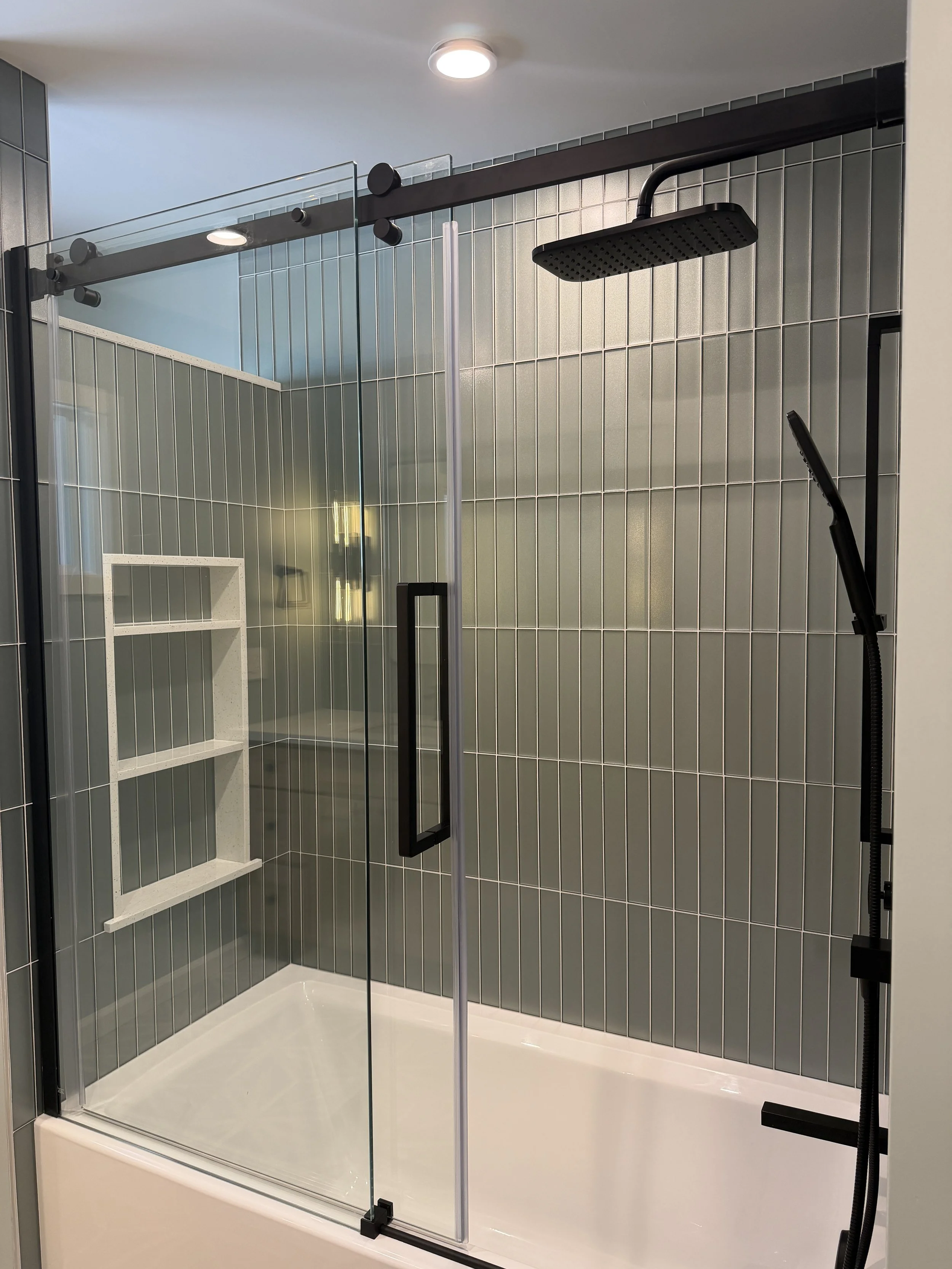 Bathtub Renovation with Glass Tiles and stone niche accents