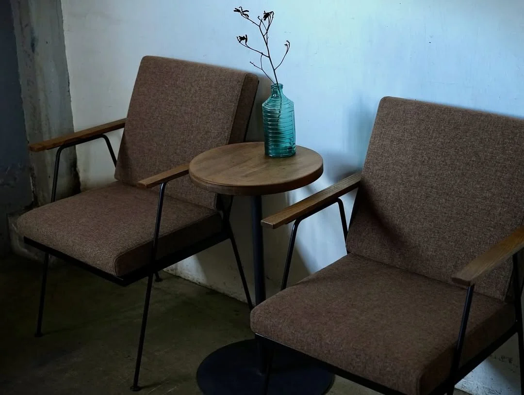 木製の丸いテーブルと左右に茶色の背もたれ付きの椅子