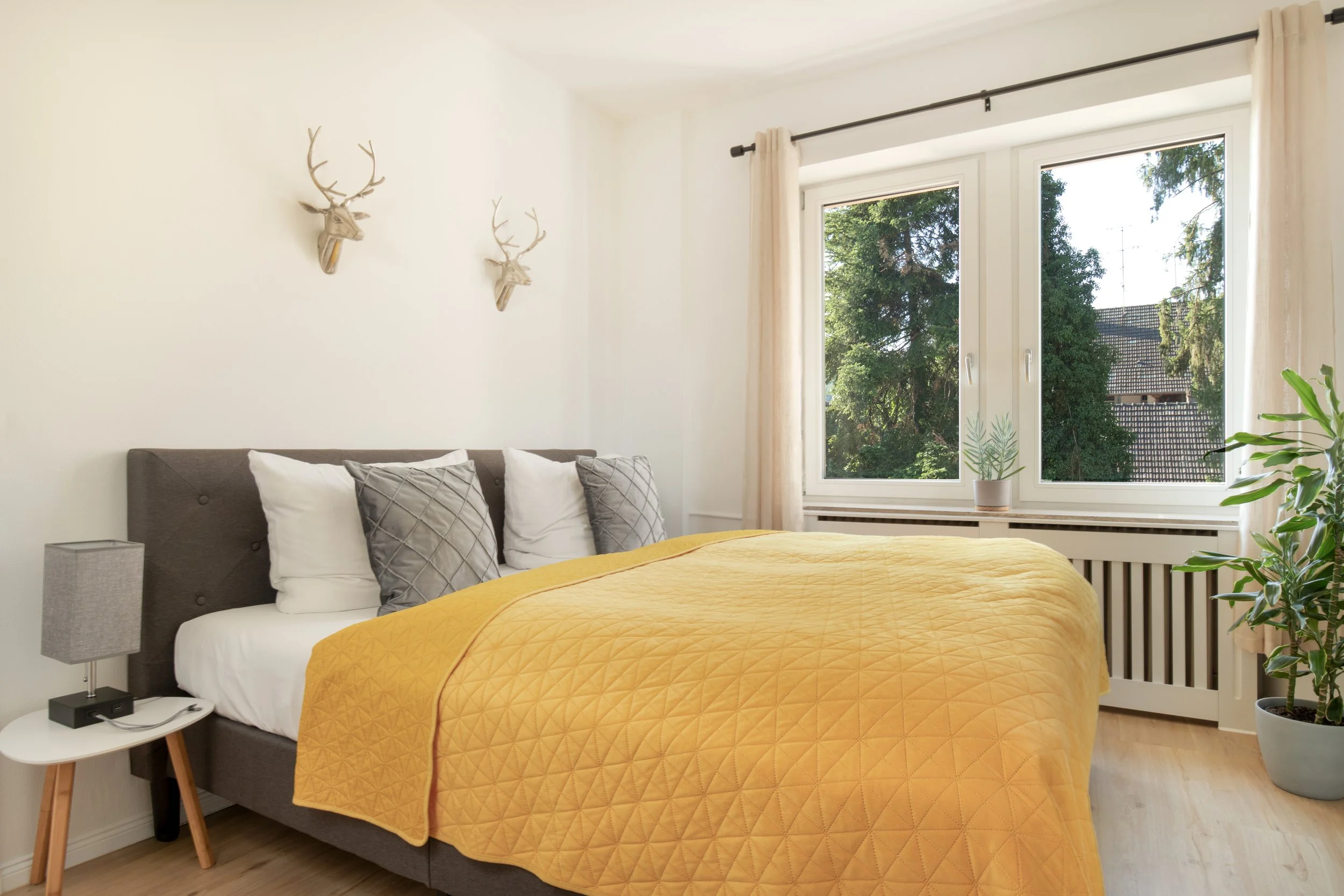 Helles Schlafzimmer mit gemütlichem Kingsize-Bett und Blick ins Grüne – ideal für erholsame Nächte.
