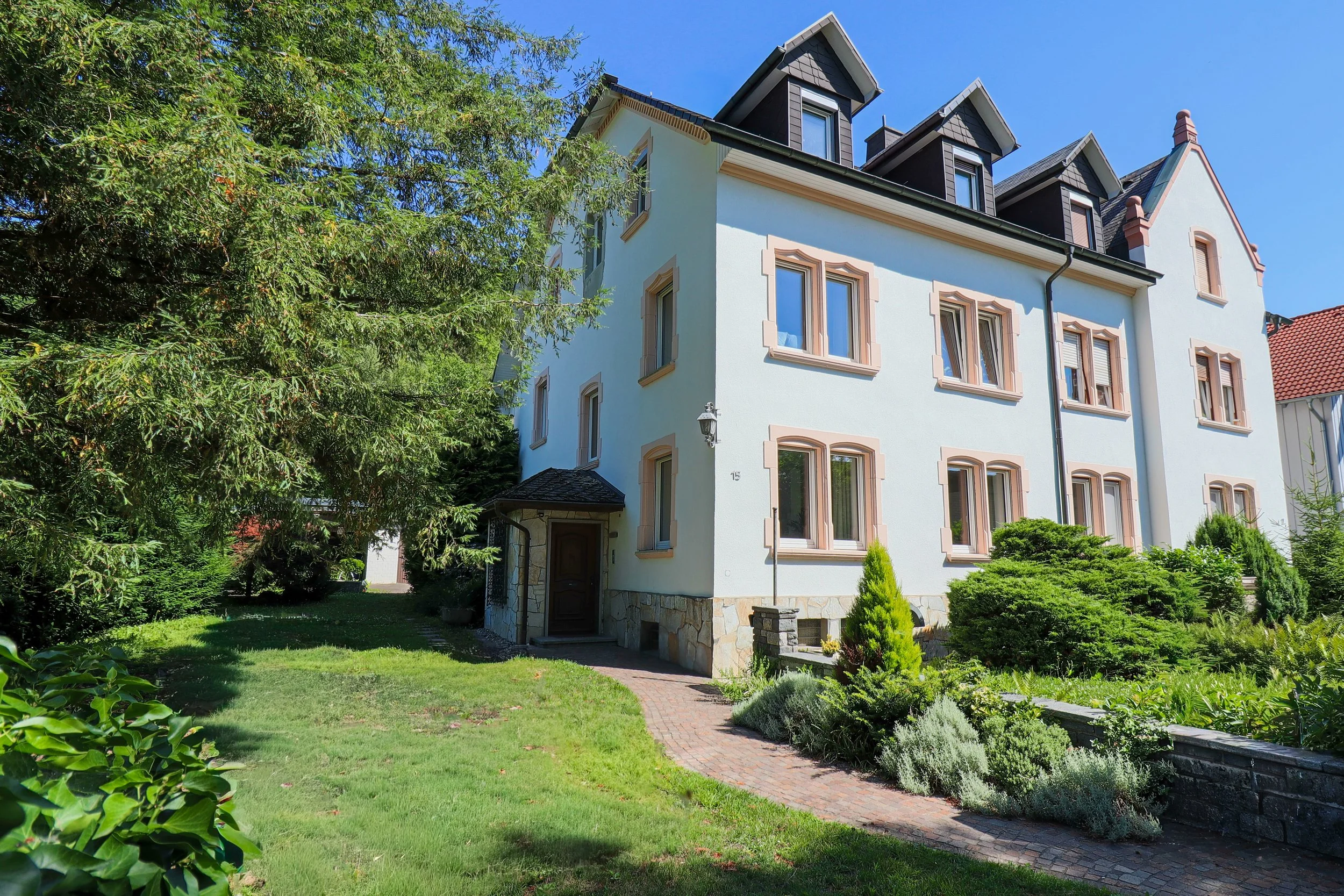 Außenansicht des Hauses mit gepflegtem Garten – hier befindet sich das gemütliche Apartment Gelb in einer ruhigen, grünen Umgebung.

