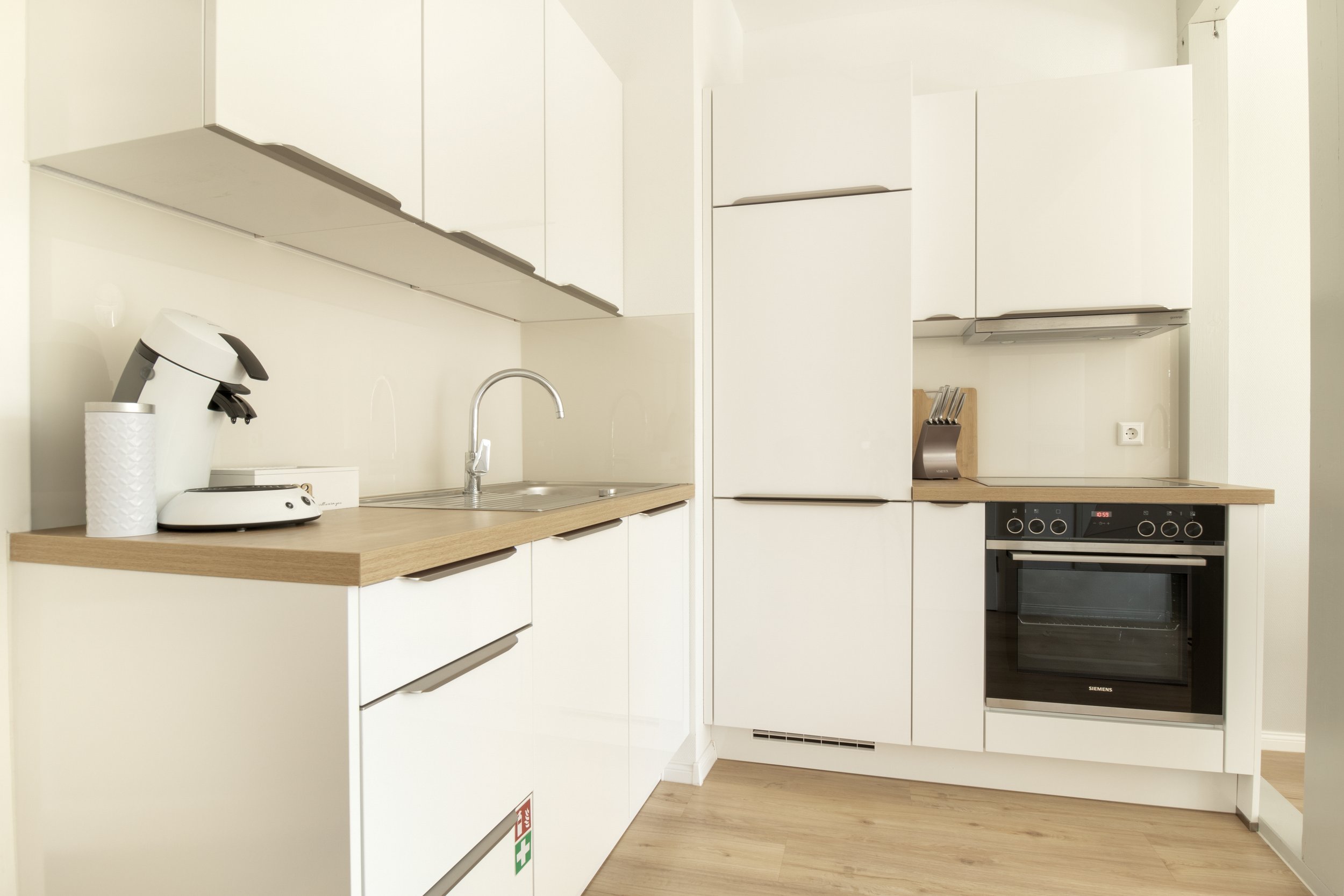 Moderne Küche mit Backofen, Herd, Kühlschrank und reichlich Arbeitsfläche – ideal zum gemeinsamen Kochen.
