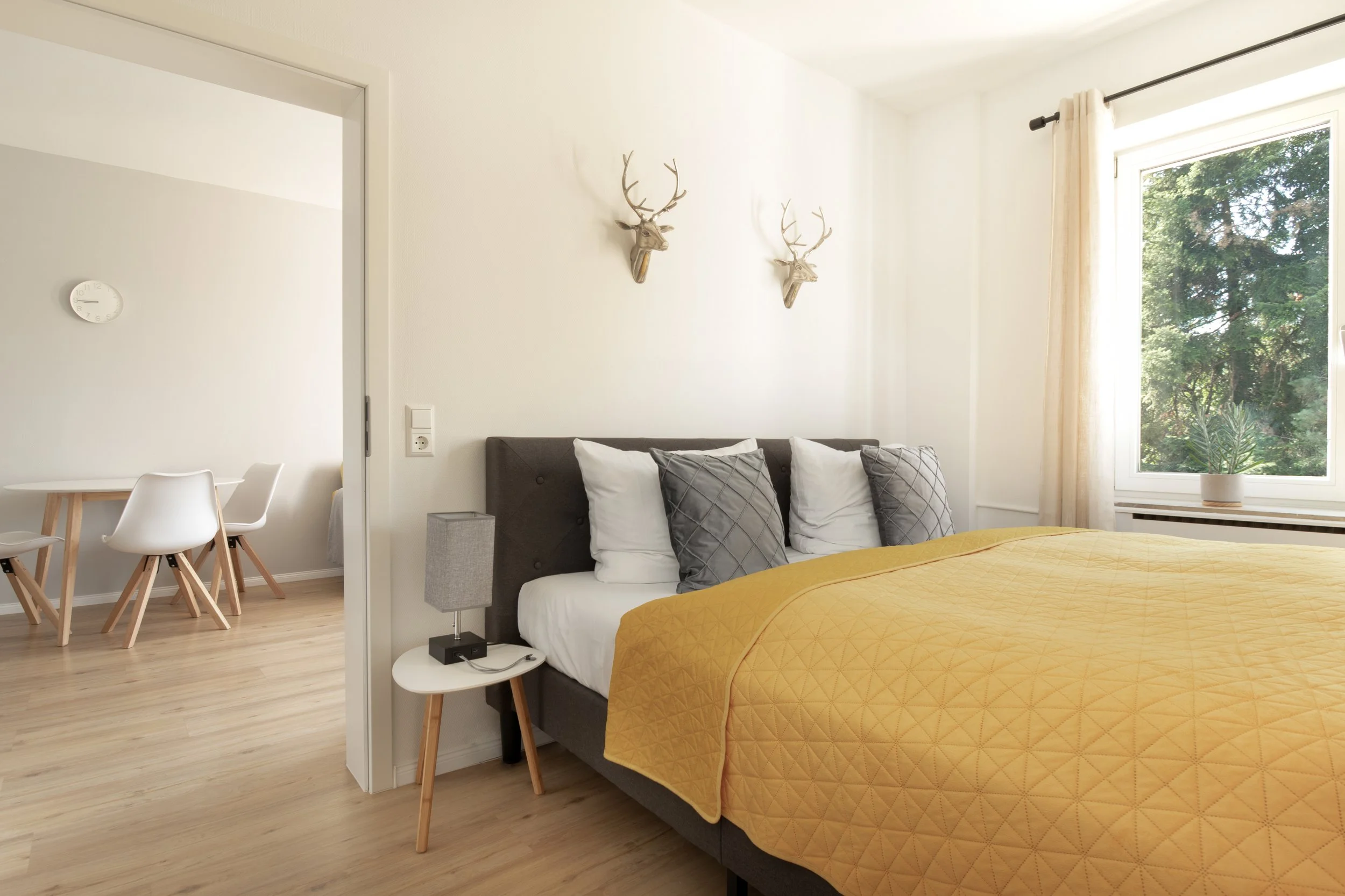 Modern eingerichtetes Schlafzimmer mit Kingsize-Bett, warmen Farben und ruhiger Atmosphäre.
