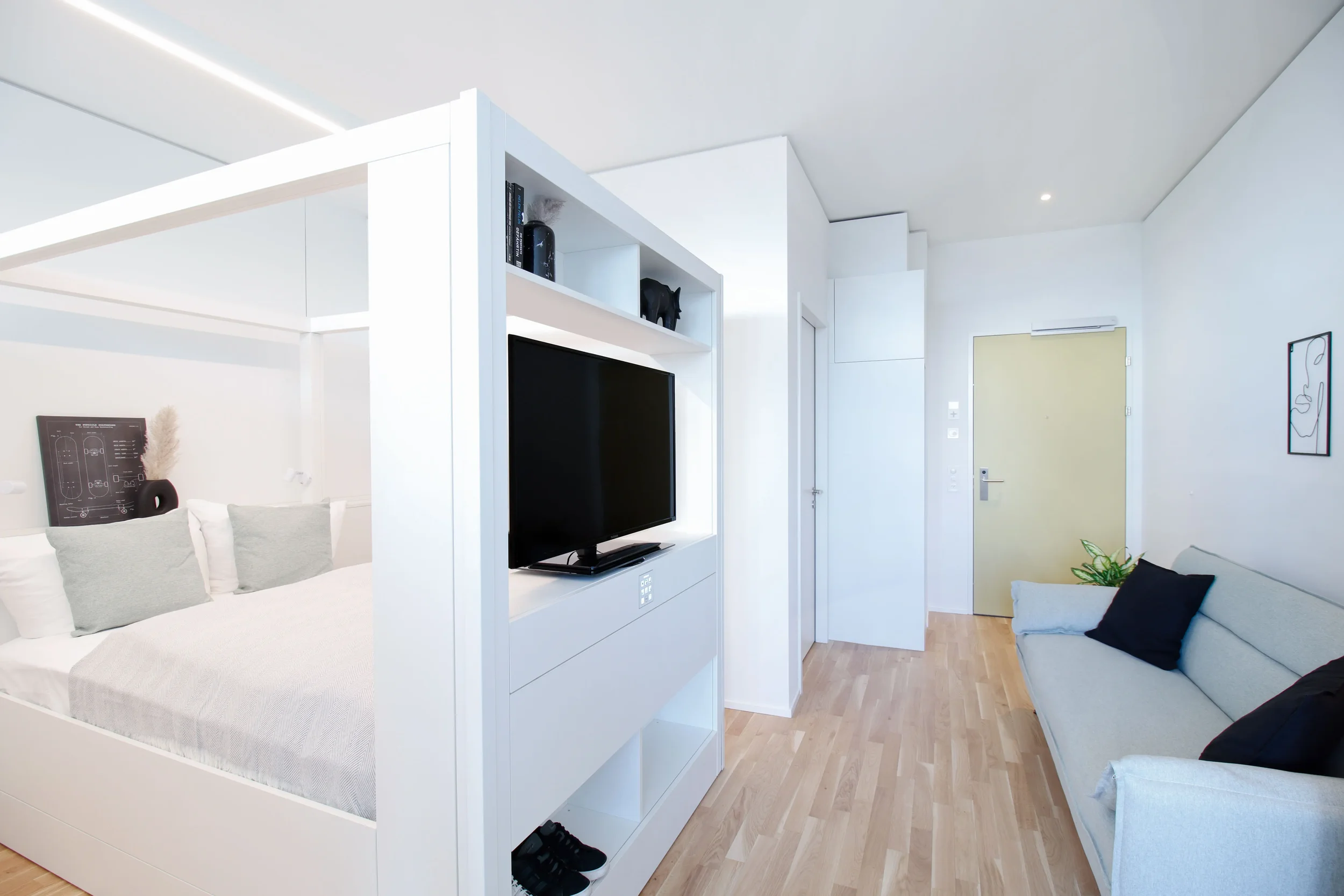 apartment-grau-bett-tv-wandsystem-innenansicht.webp