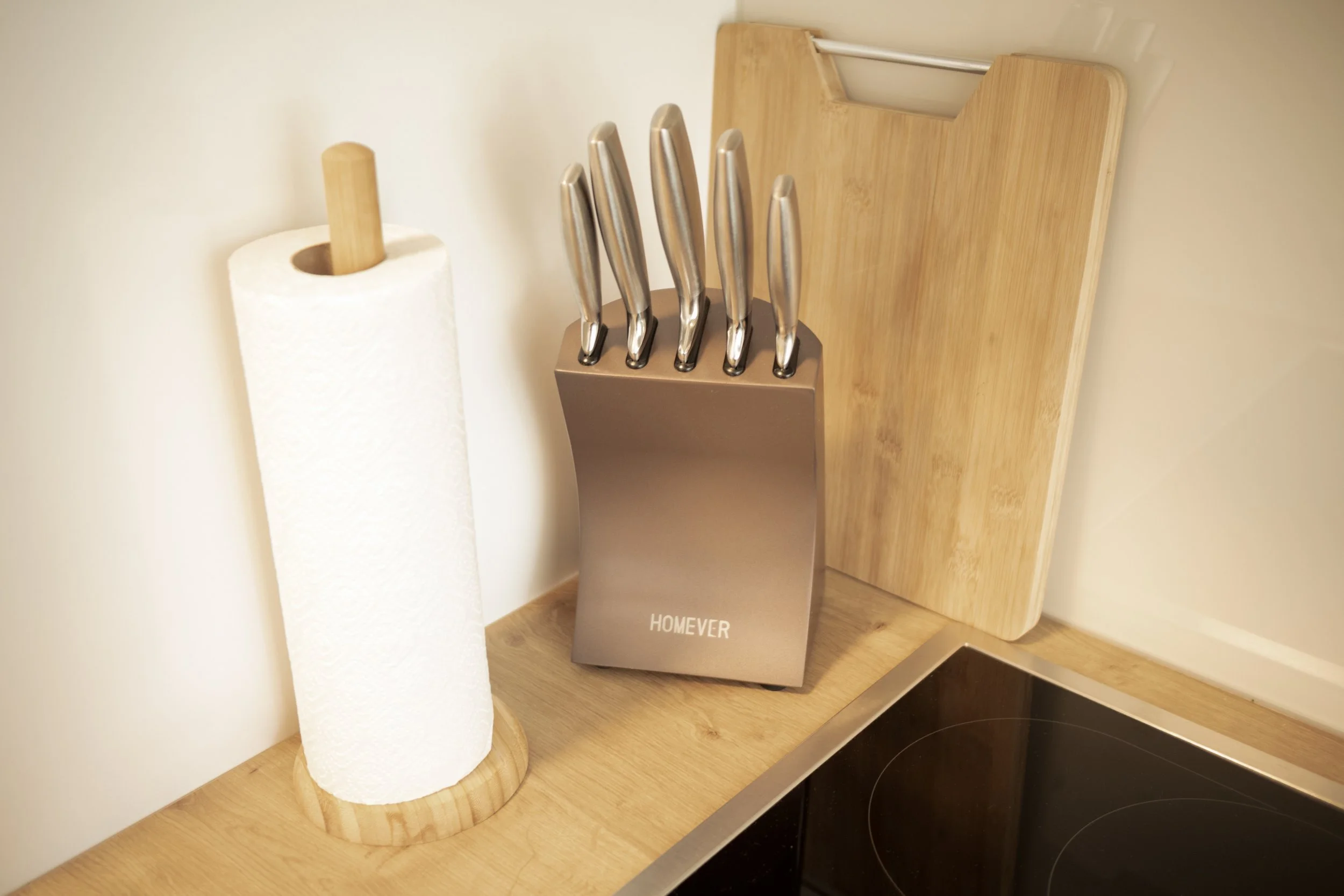 Praktische Vorbereitungsecke mit hochwertigem Messerblock und Küchenpapier – ideal für entspanntes Kochen.

