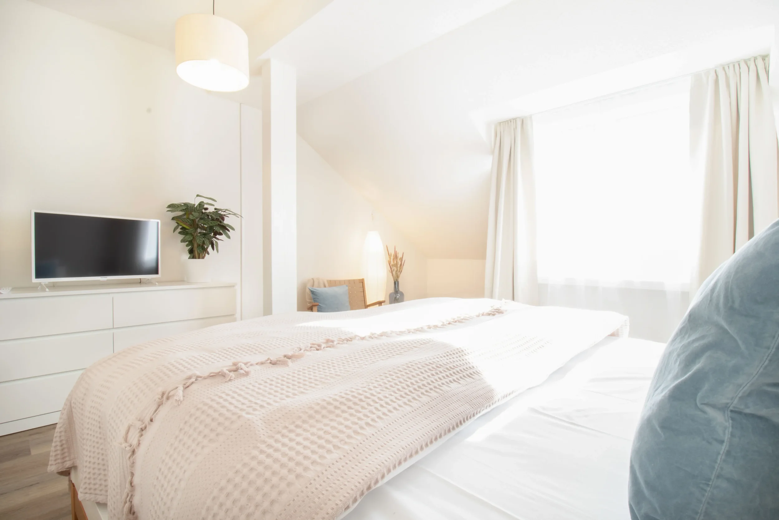 apartment-blau-schlafzimmer-tv-kommode-lichtdurchflutet.webp