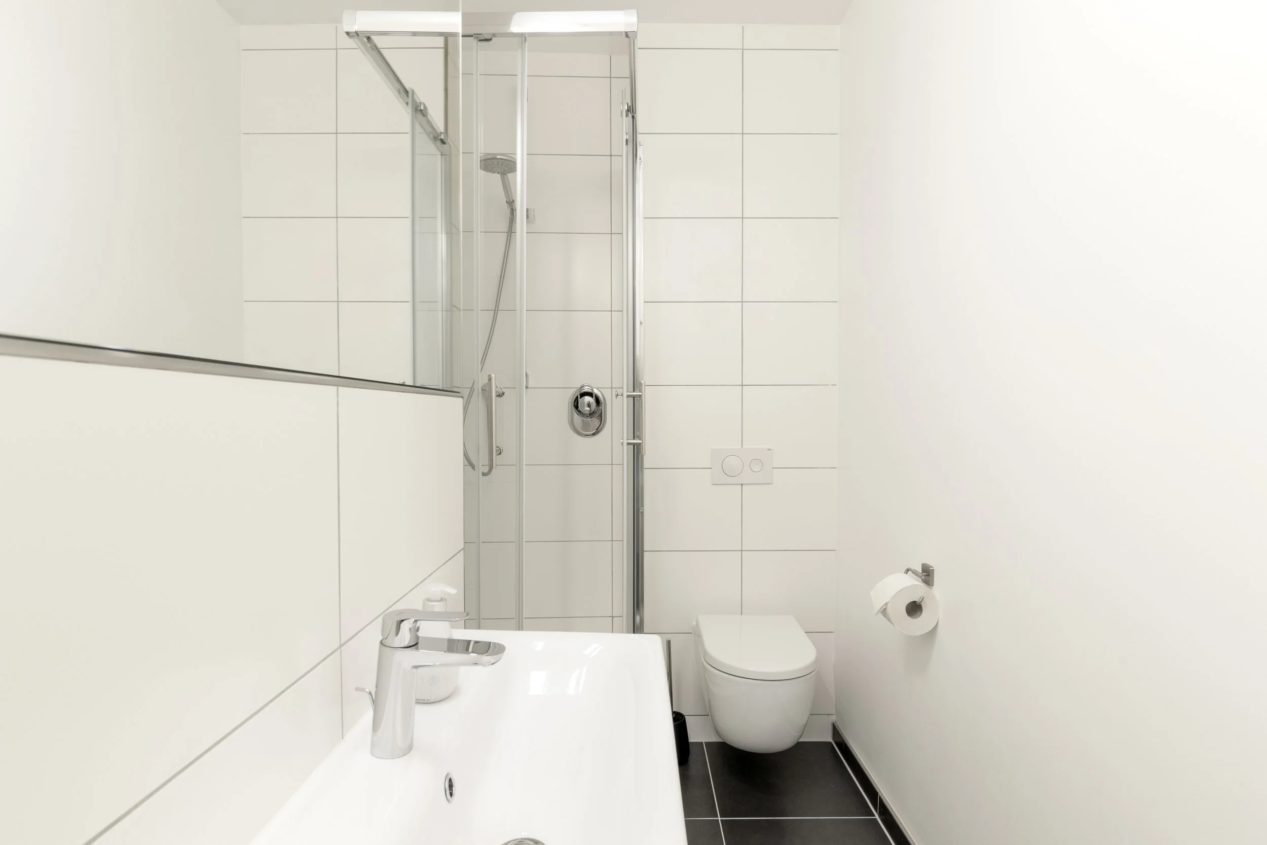 Sauberes Bad mit Dusche und WC, schlicht und funktional gestaltet für maximalen Komfort.
