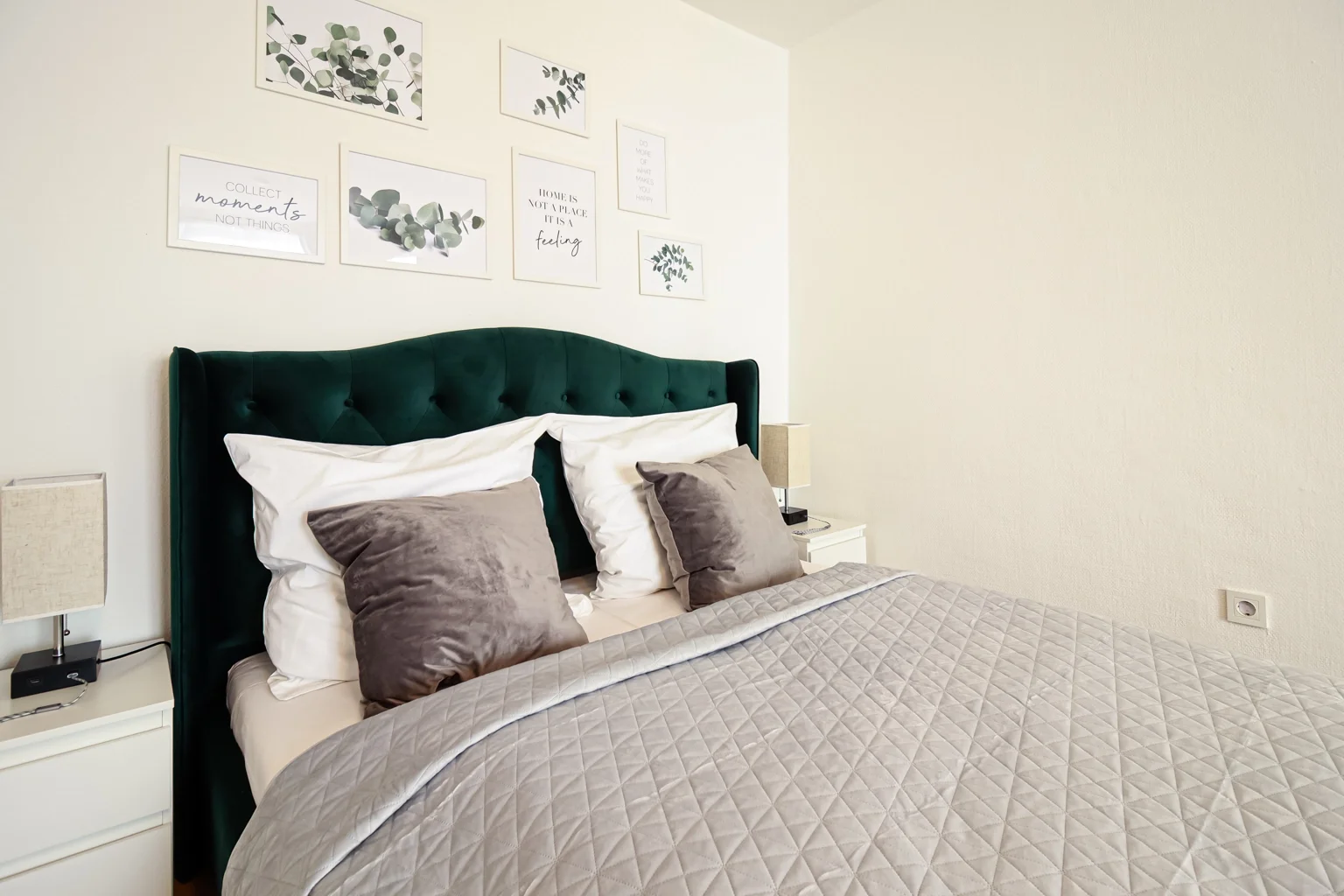 Schlafzimmer im Apartment Grün in Küssaberg mit grünem Bettkopfteil, hellen Textilien und ruhiger Einrichtung