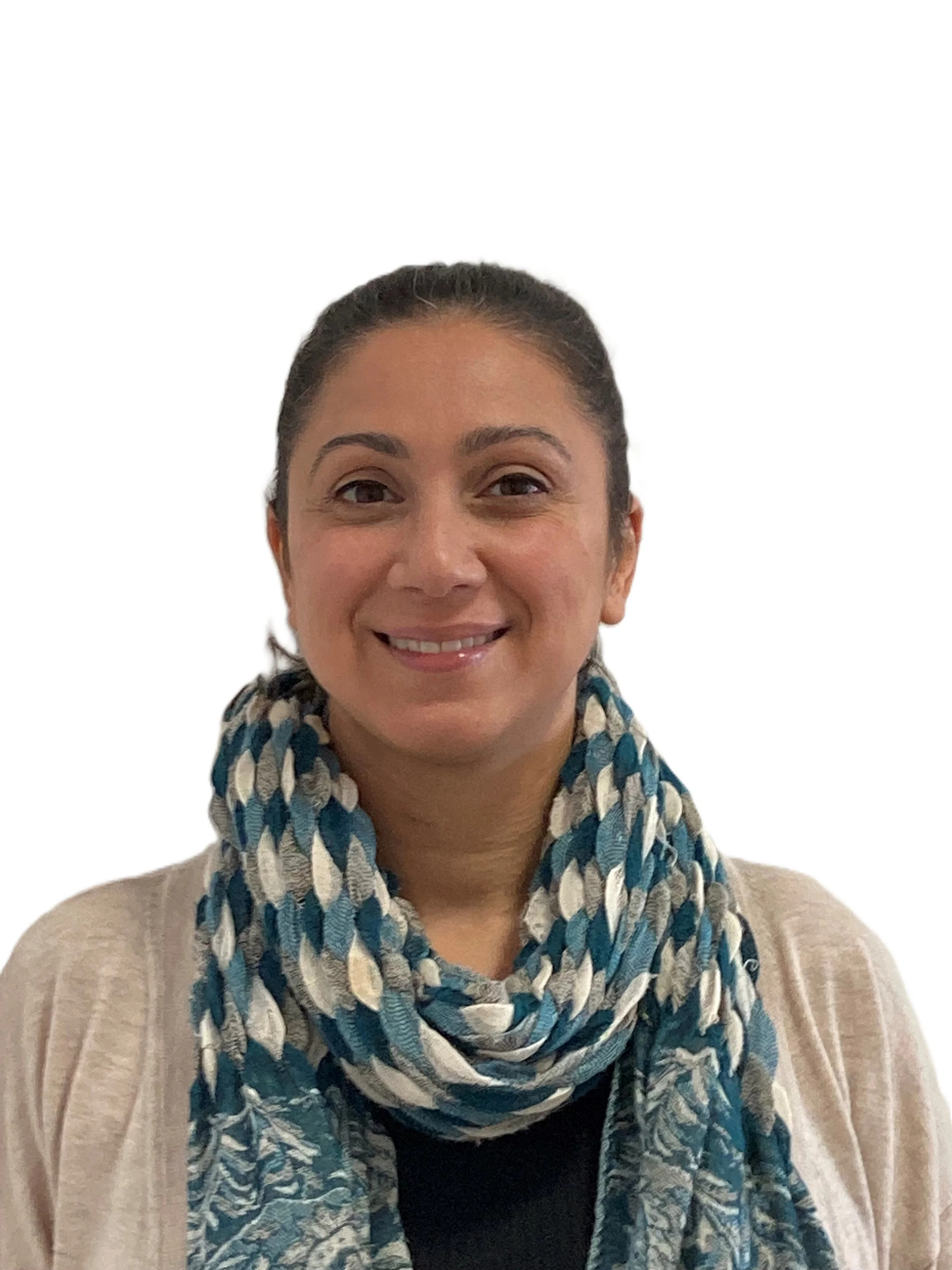 A woman smiling, wearing a beige cardigan and a blue, white, and gray patterned scarf.