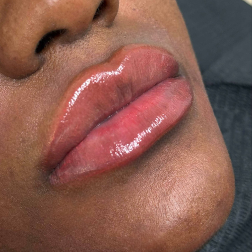 Lèvres pulpeuses avec coloration glamour sur un visage sombre.